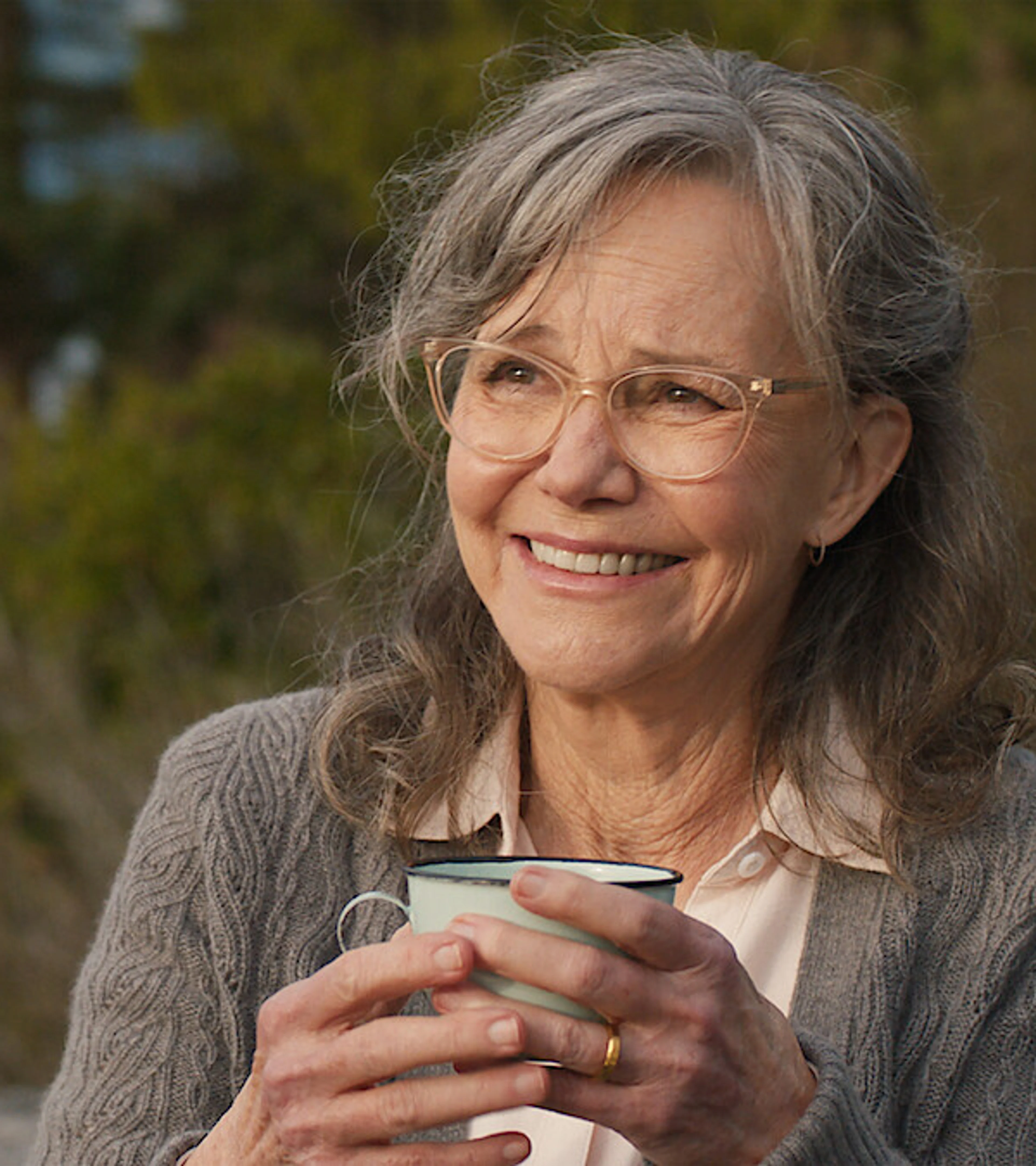 Sally Field as Tova smiles while holding a cup in official Remarkably Bright Creatures artwork.