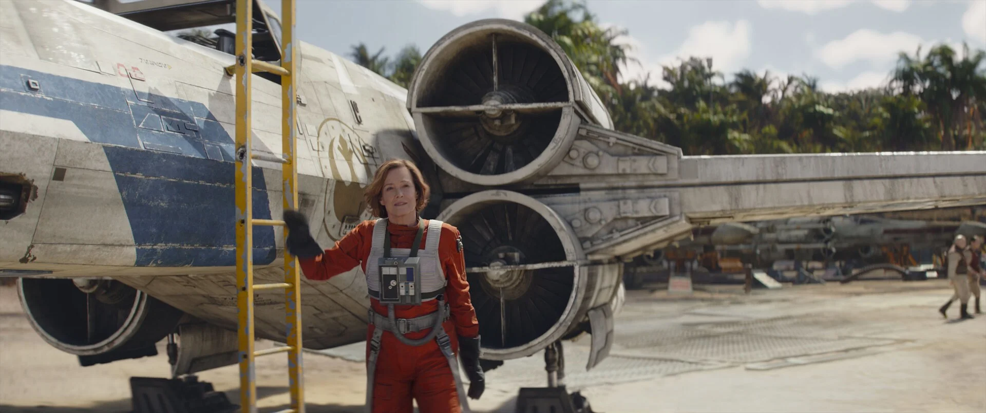 Sigourney Weaver as Colonel Ward stands beside a parked spacecraft.