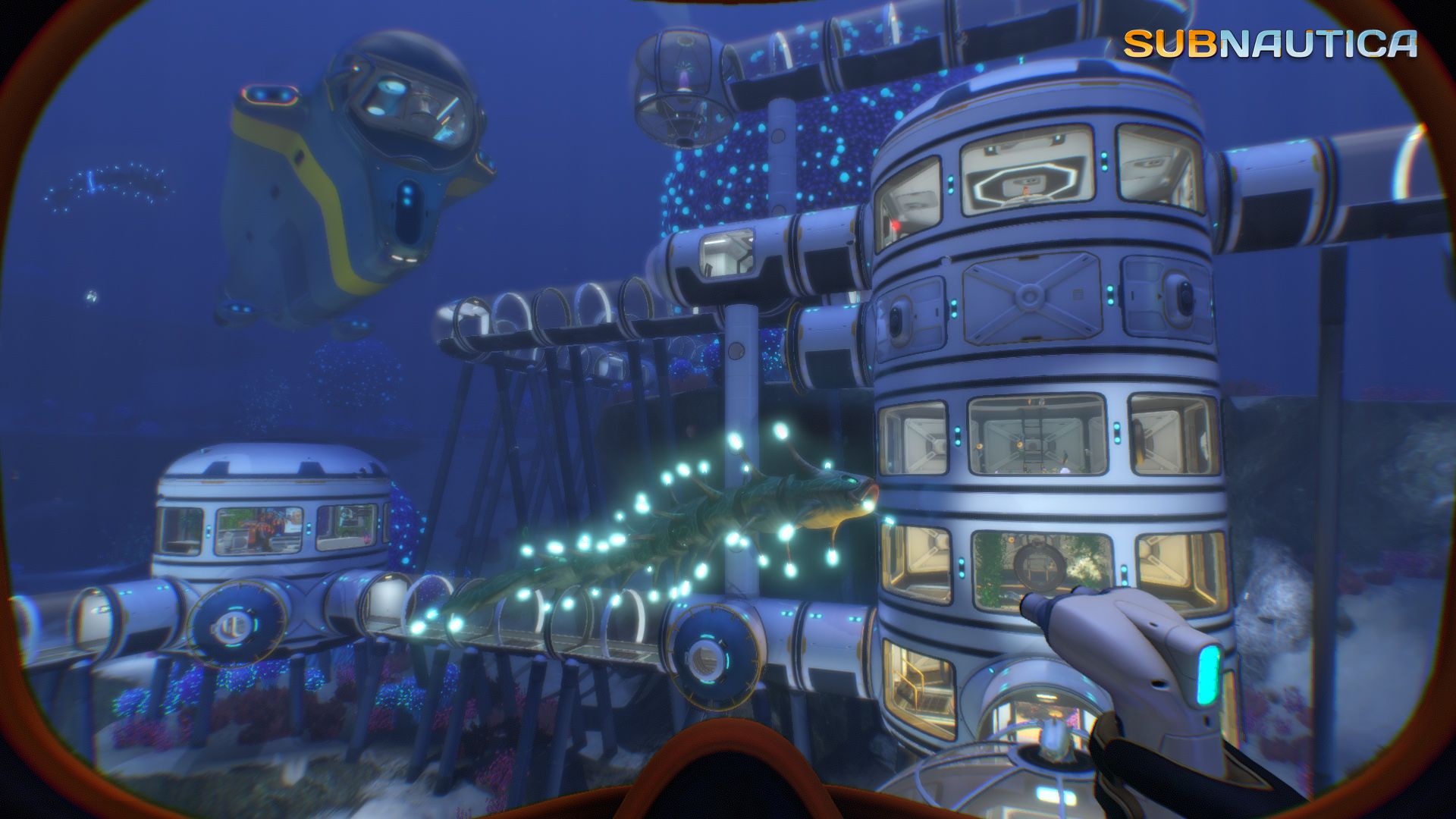 A large modular underwater base stands on the sea floor with connected rooms and windows.