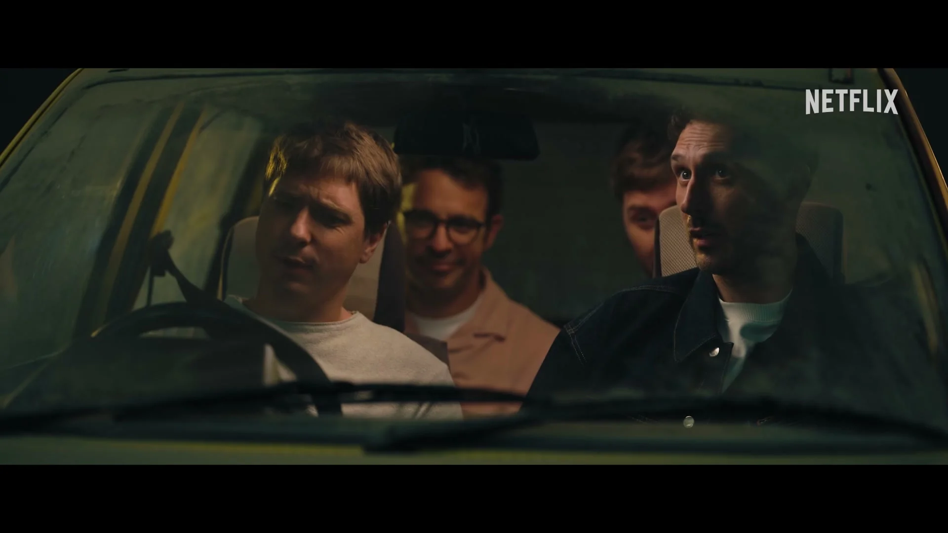 Simon Bird, Joe Thomas, James Buckley and Blake Harrison sit together inside the yellow car.