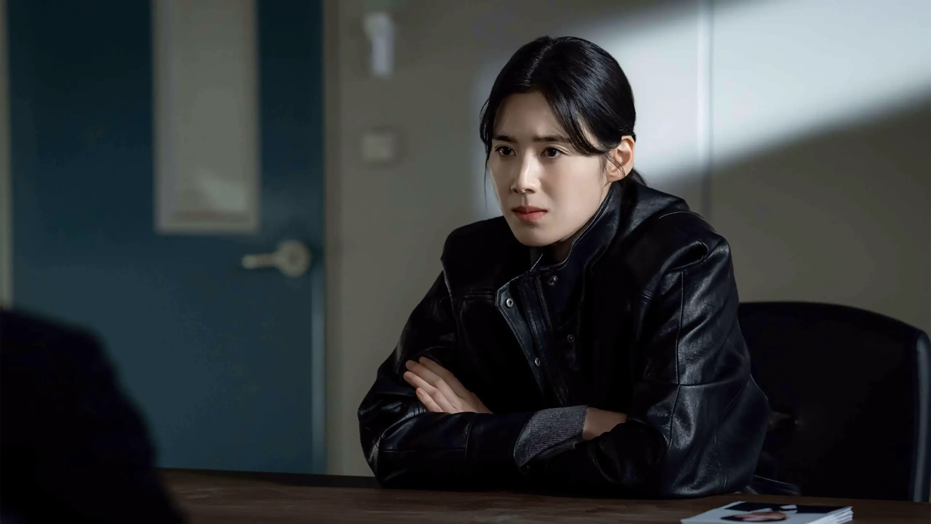 Joo Hye-ra sits at a table in a police station.