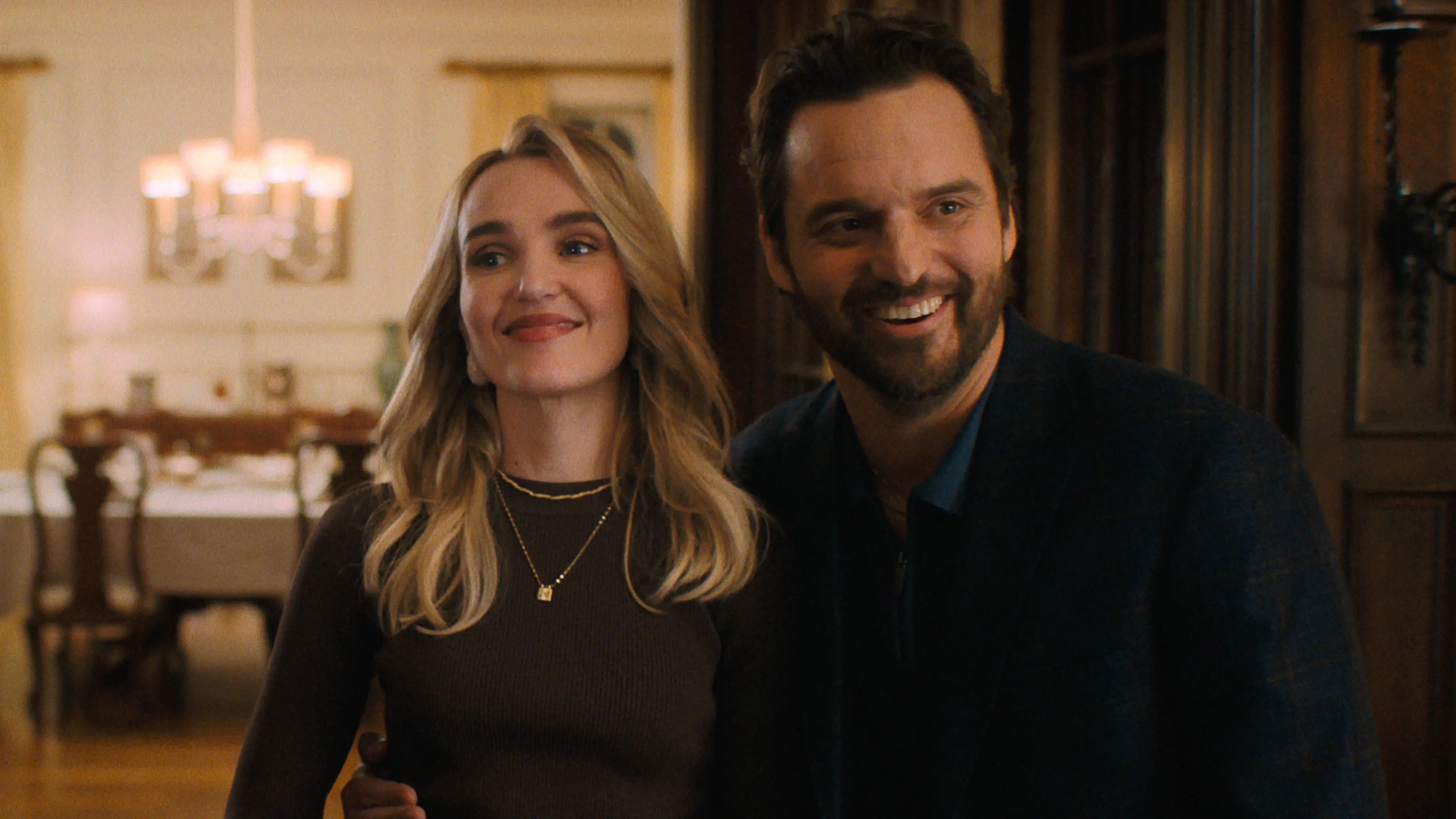Chloe Fineman and Jake Johnson stand together indoors.