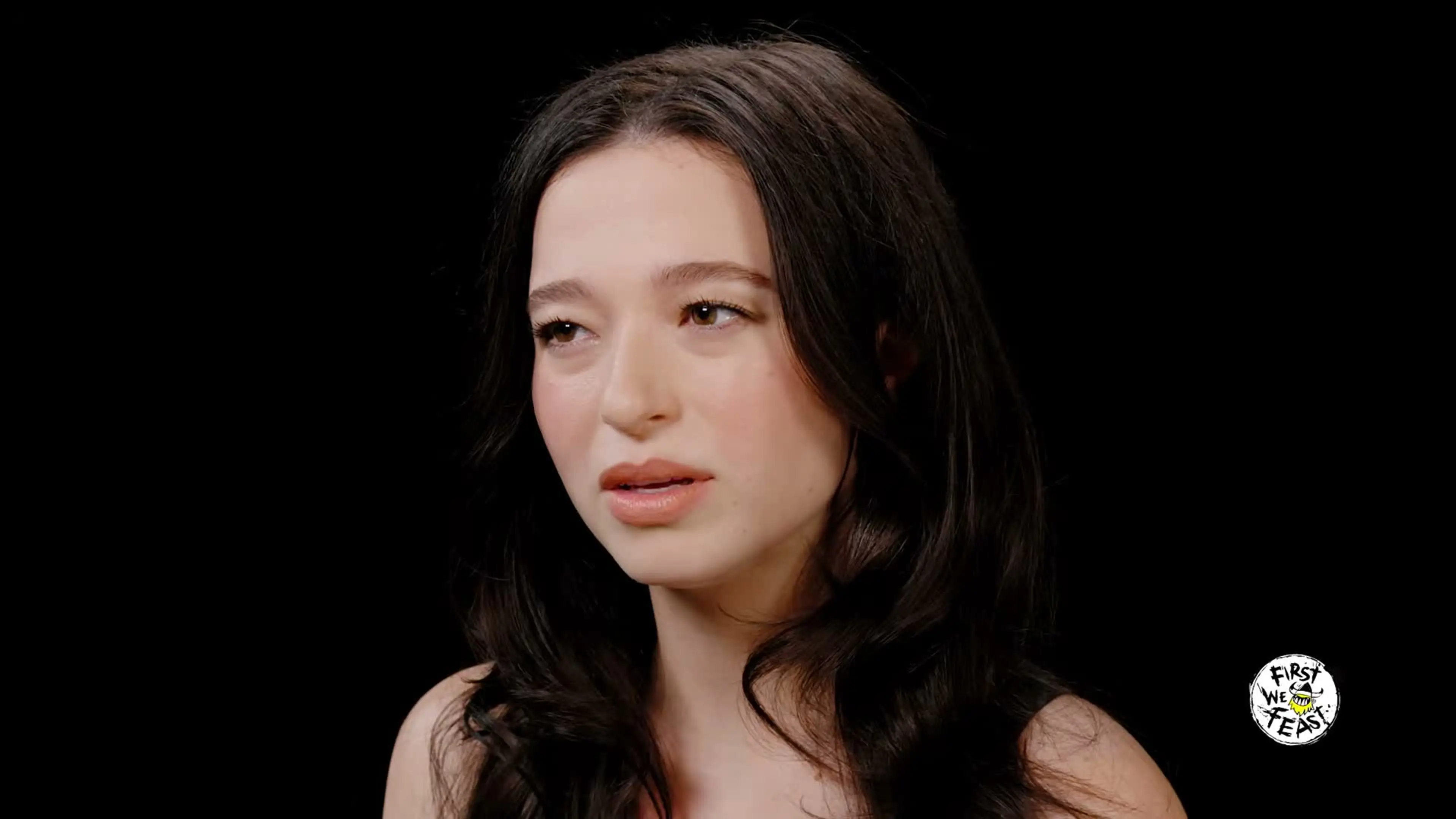 Mikey Madison listens to Sean Evans during her Hot Ones interview.