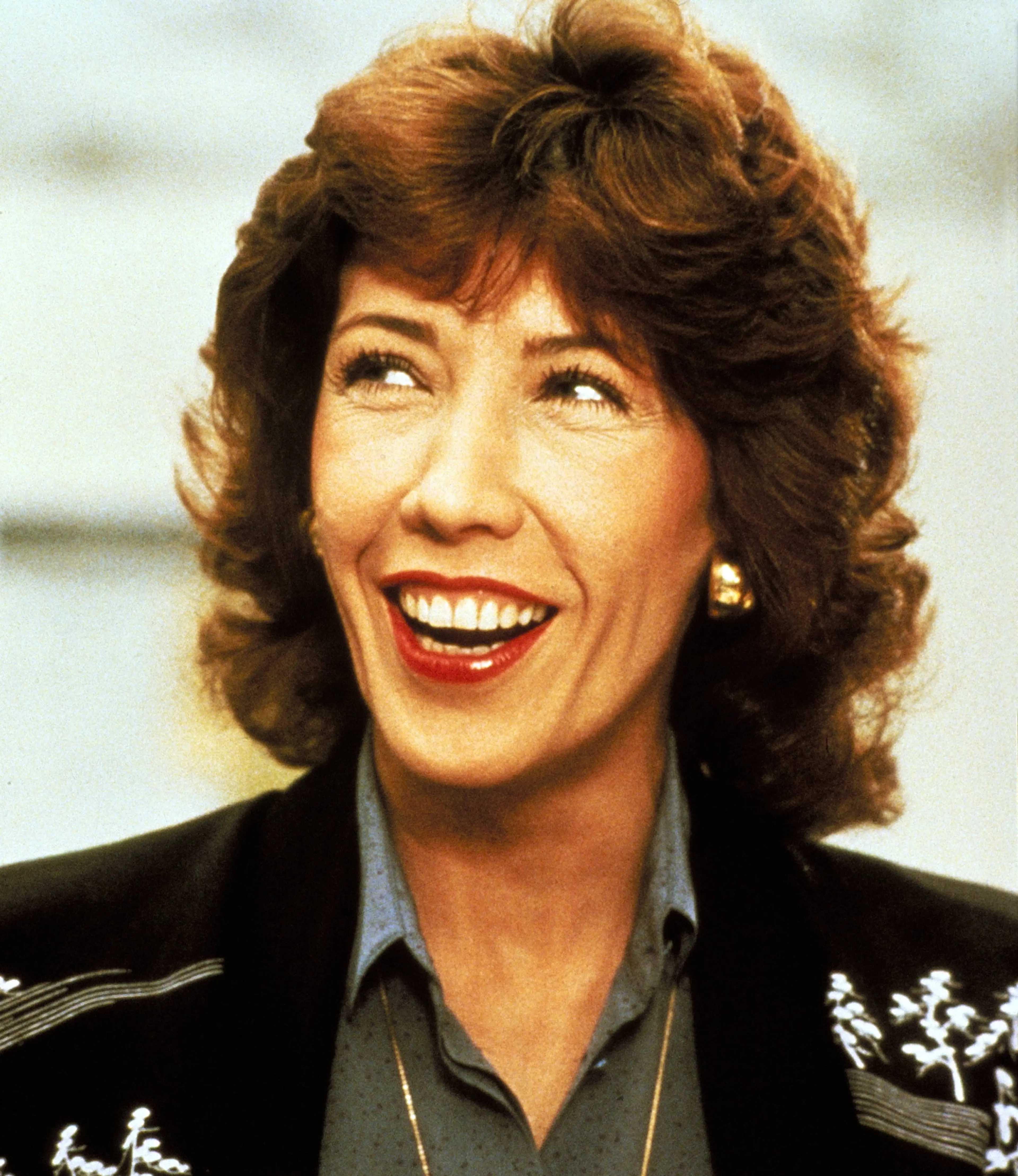 Lily Tomlin smiling in a scene from 9 to 5.
