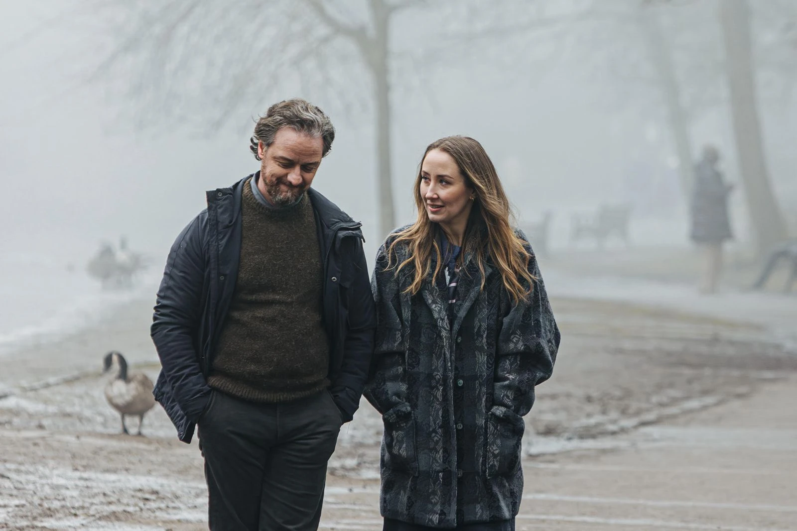 James McAvoy and Erin Doherty walk together through mist in the film Faith.
