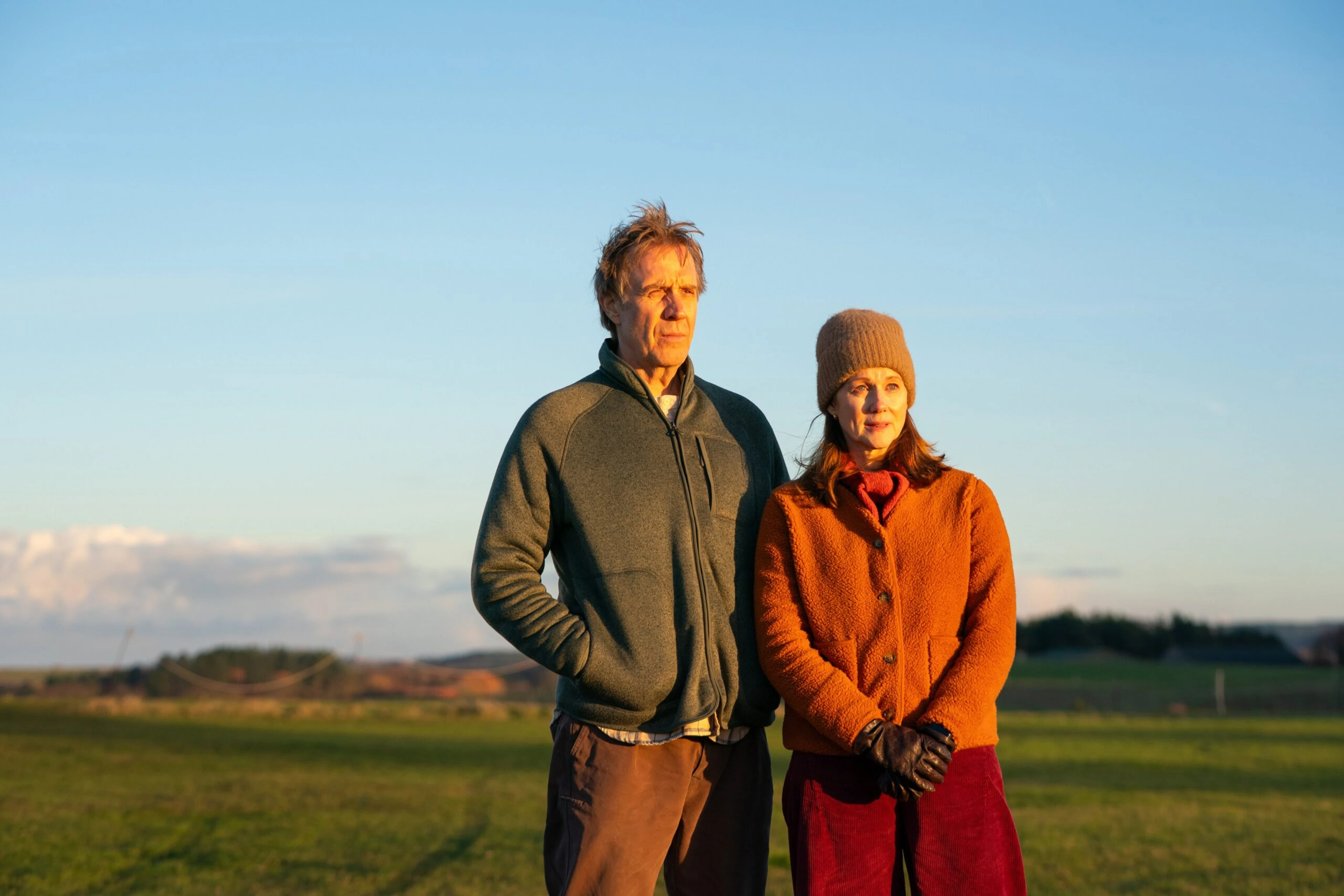 Rhys Ifans as Tony stands beside Monica Dolan as Liz outdoors in Onwards and Sideways.