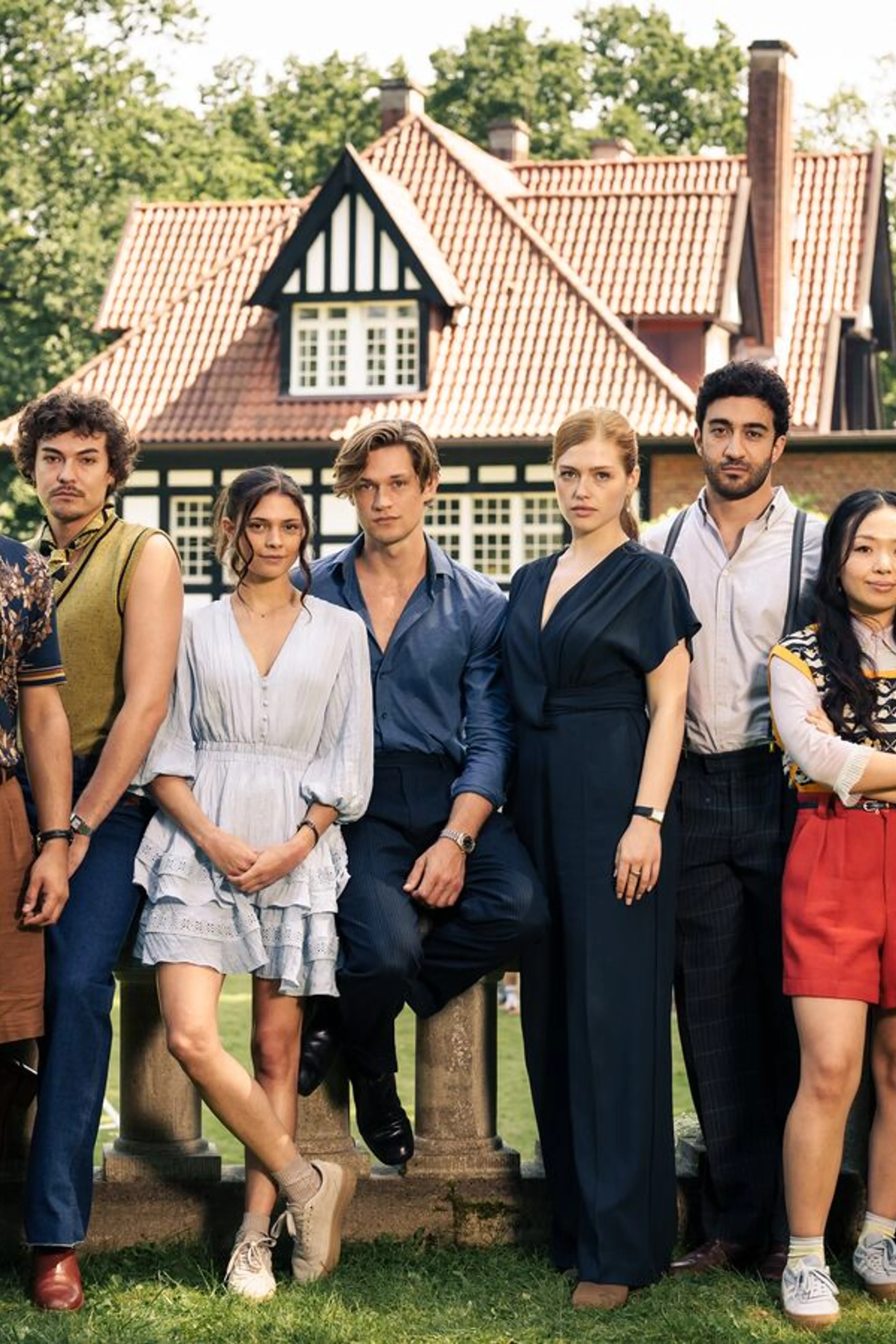 The Maxton Hall Season 3 cast poses together in a garden outside the school.