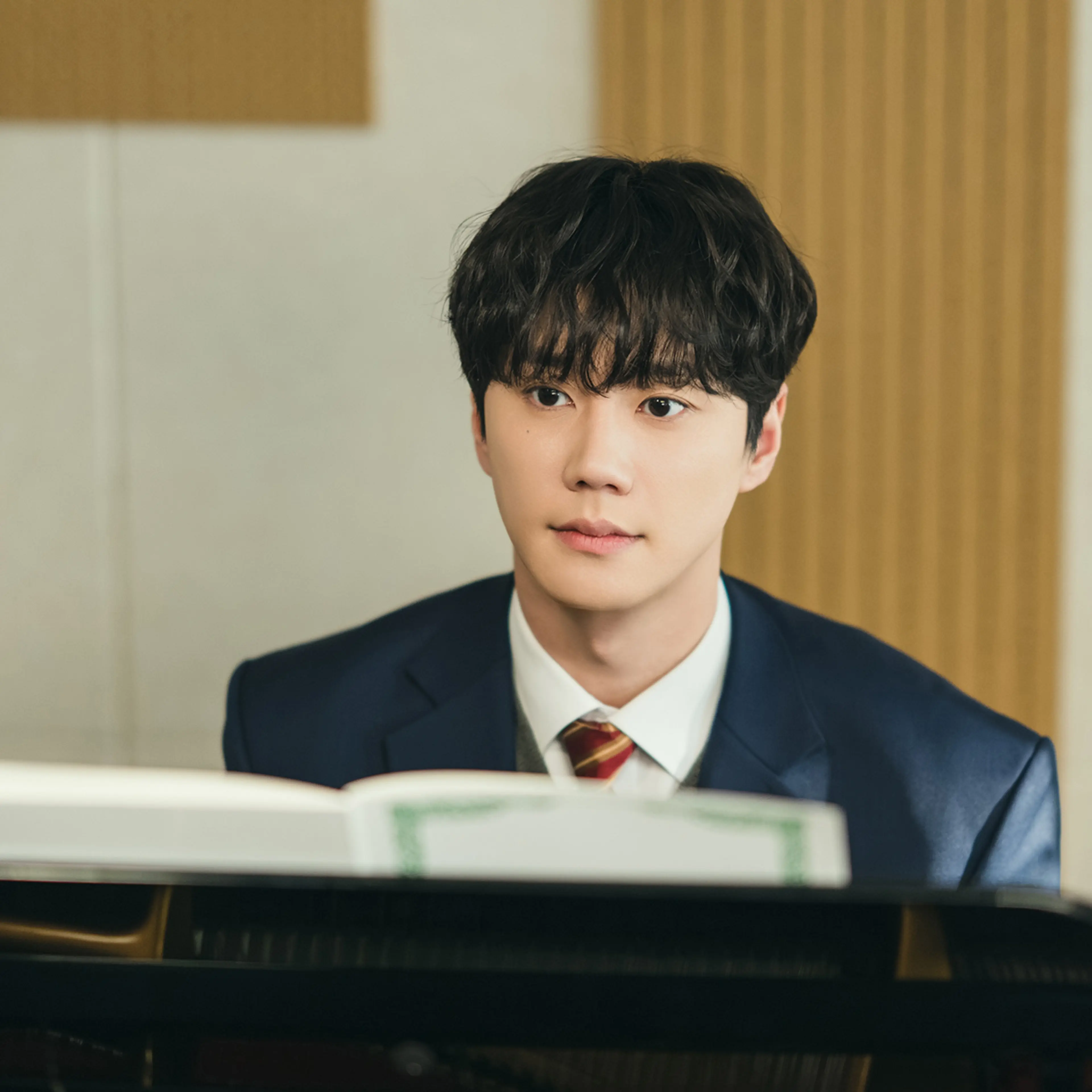Lee Jun-young as Choi Jeong-yo stands in a music room in Four Hands, Two Sonatas.