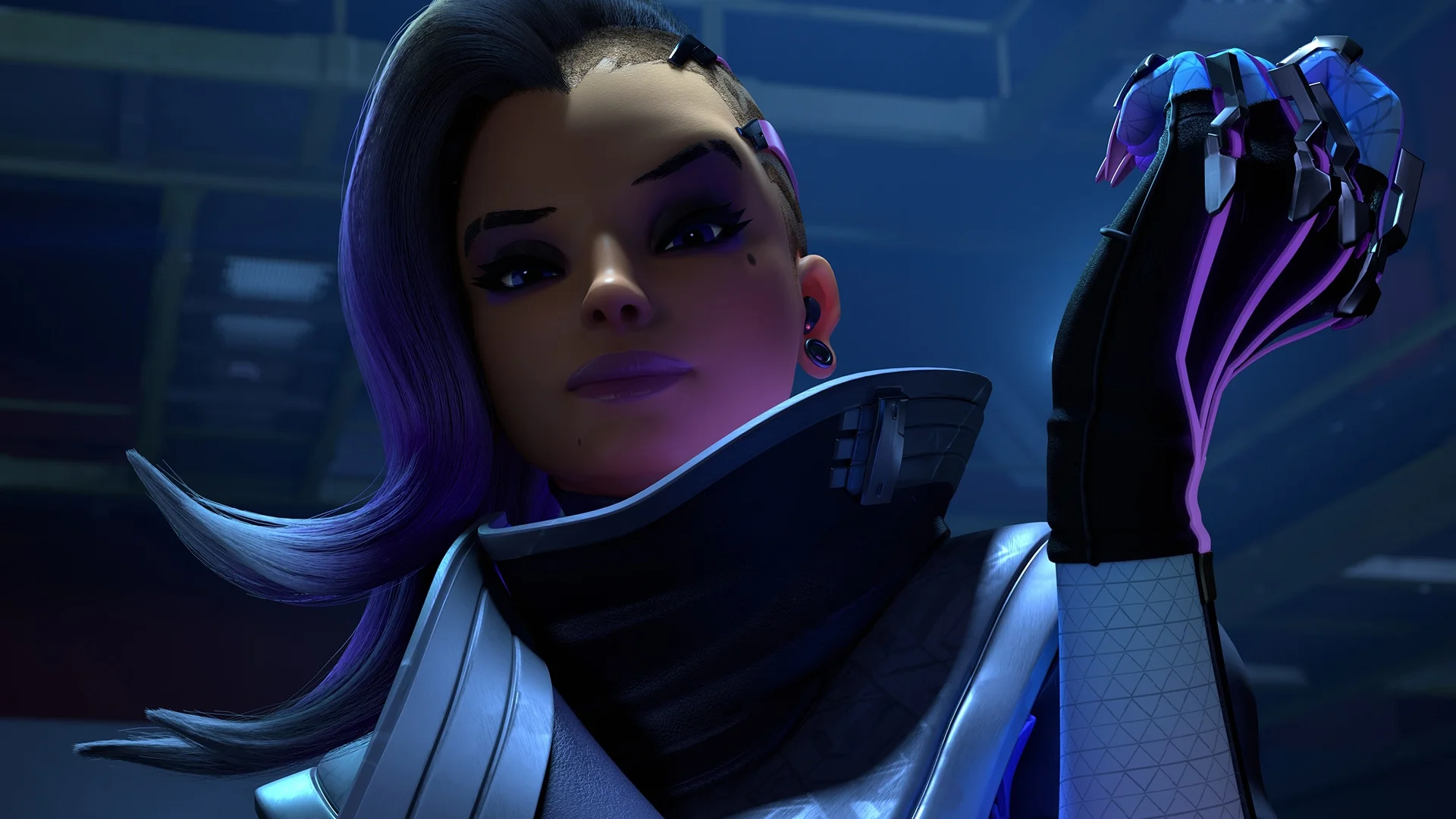 Sombra raises her cybernetic hand in a close view from Overwatch.