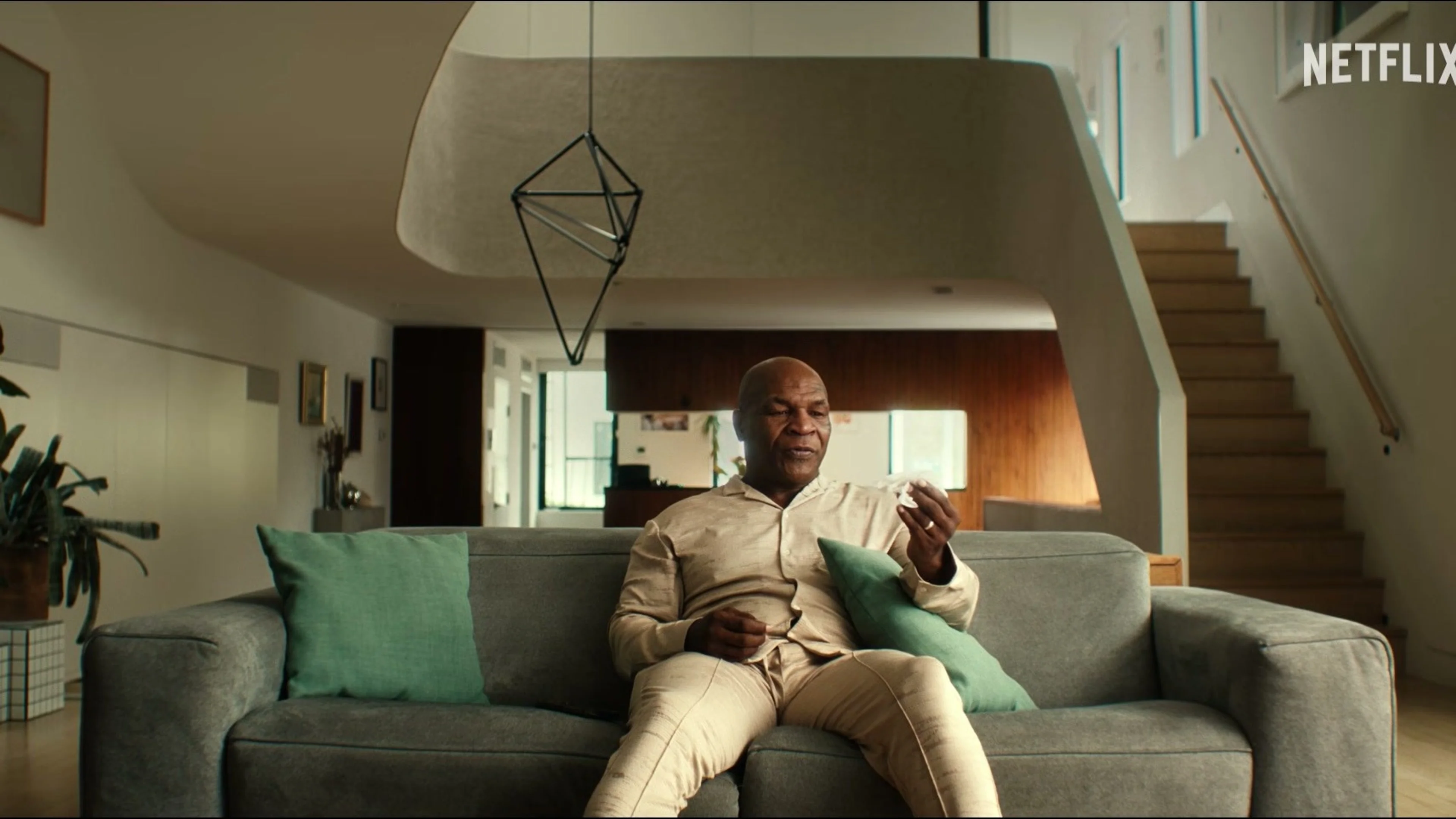 Mike Tyson sits on a sofa during a present-day interview.
