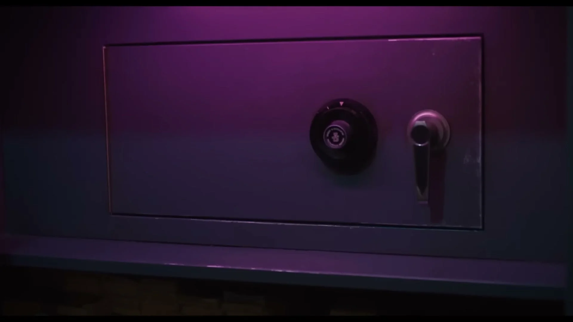A closed safe has a numbered combination dial and metal handle.