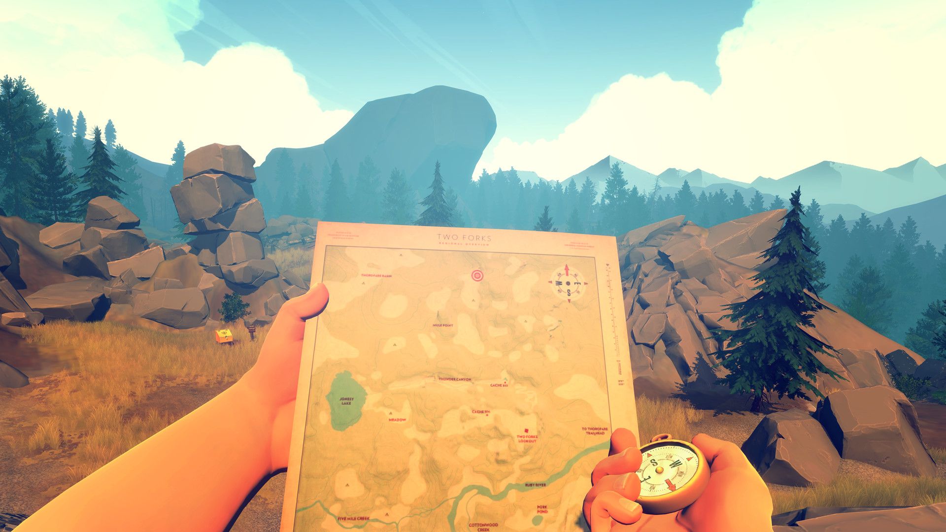 Henry holds a paper map over a mountain view.