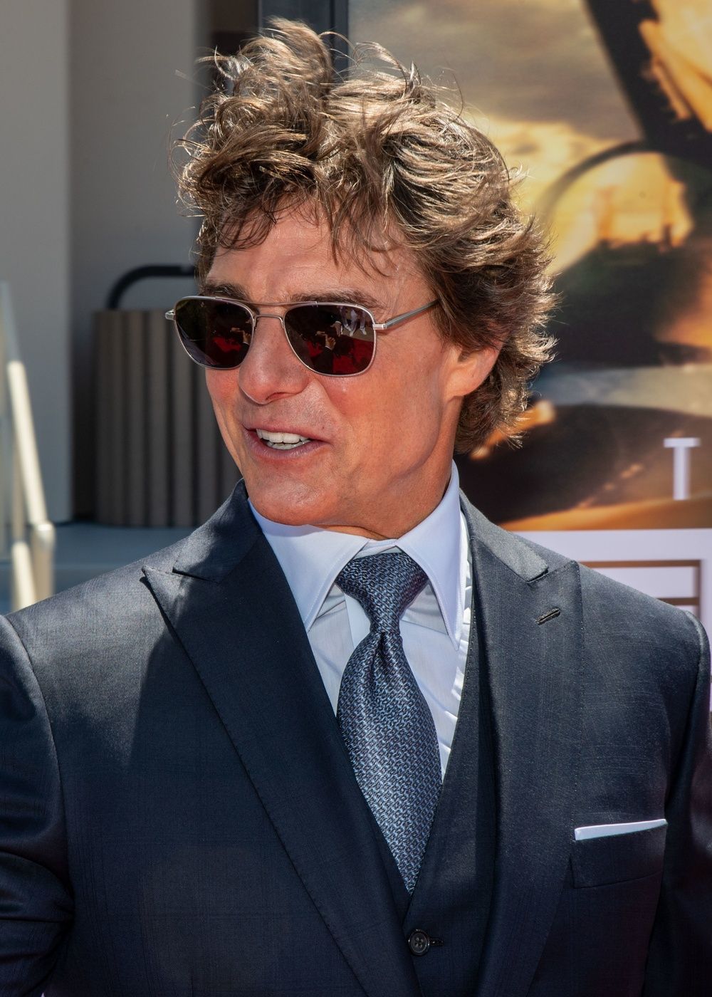 Tom Cruise in sunglasses and a dark suit at the 2022 Top Gun: Maverick premiere.