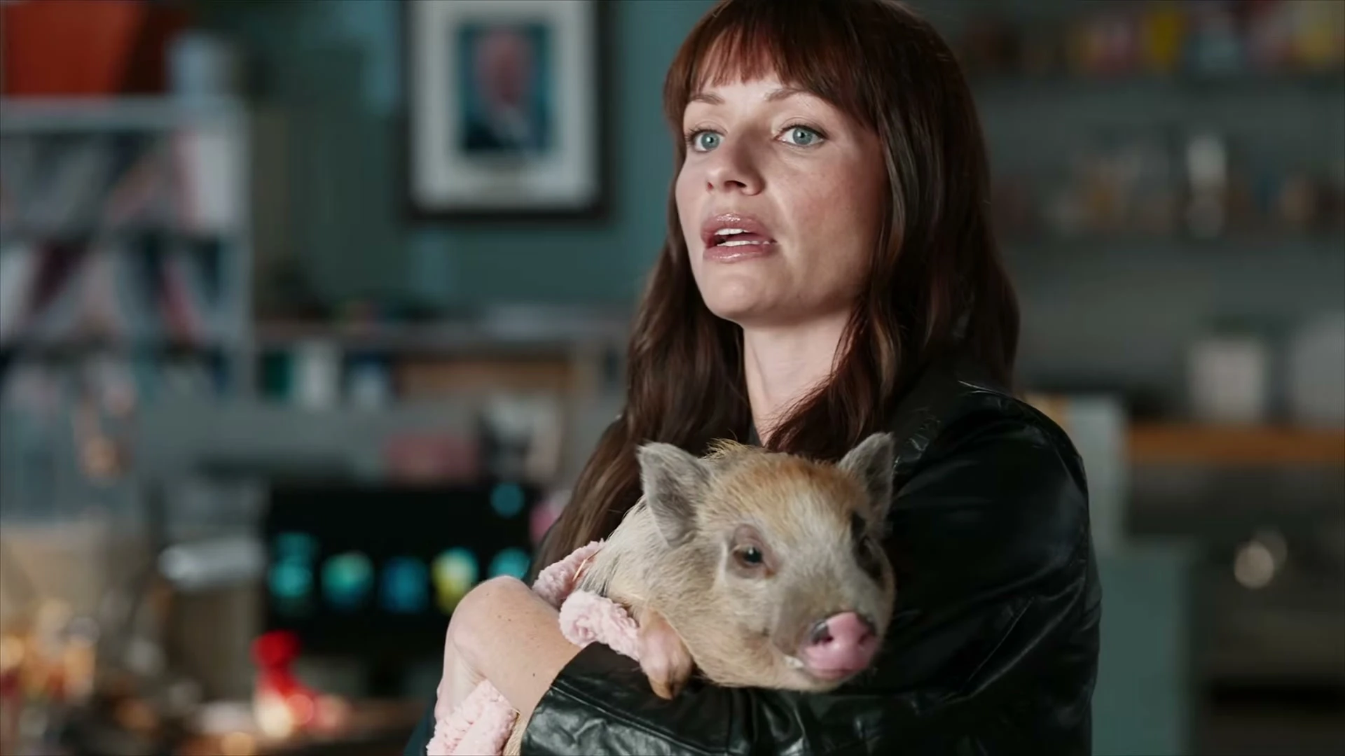 An Animal Control season-five character holds a small pig.