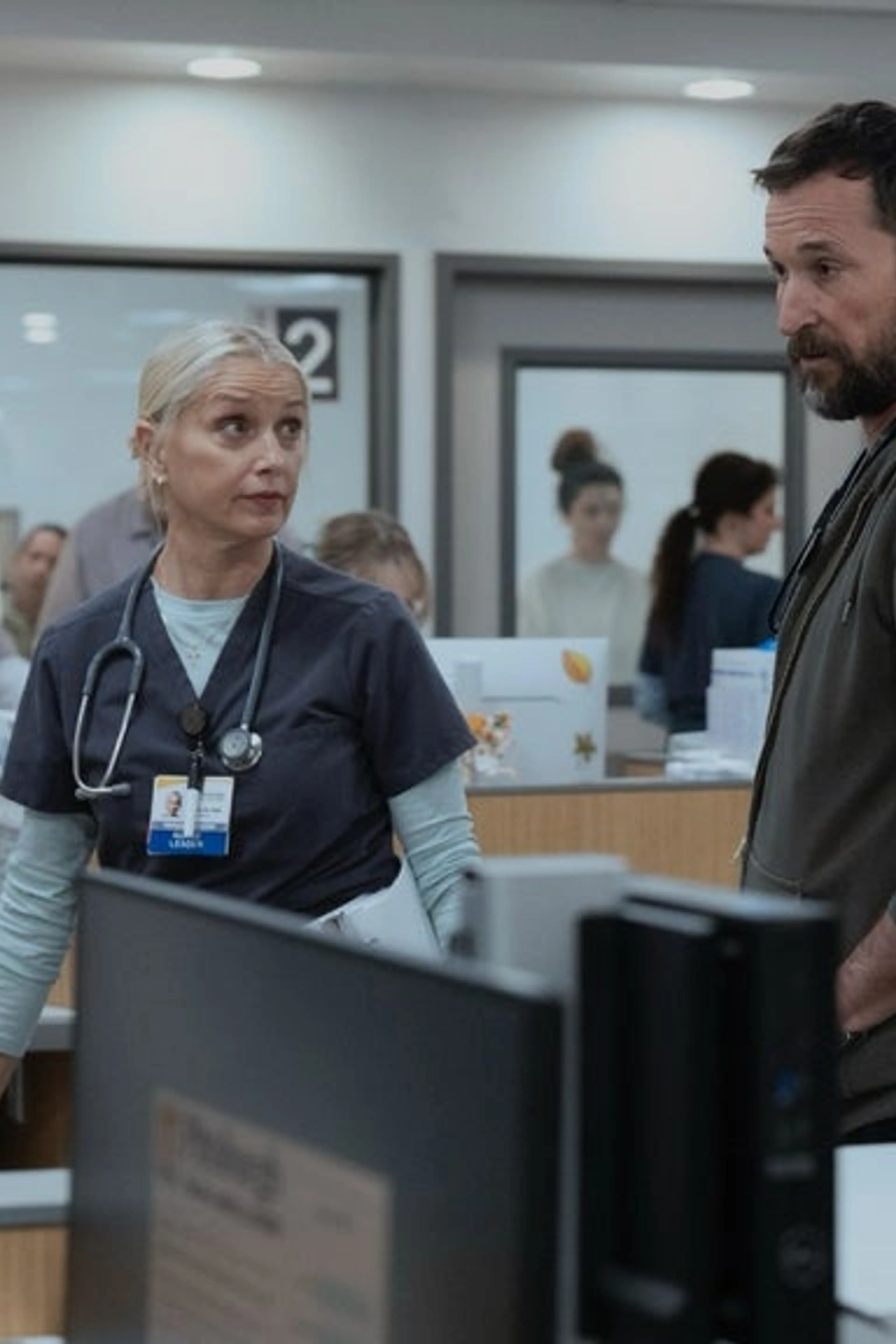 Dr. Robby talks with members of the emergency department in an official The Pitt Season 3 image.