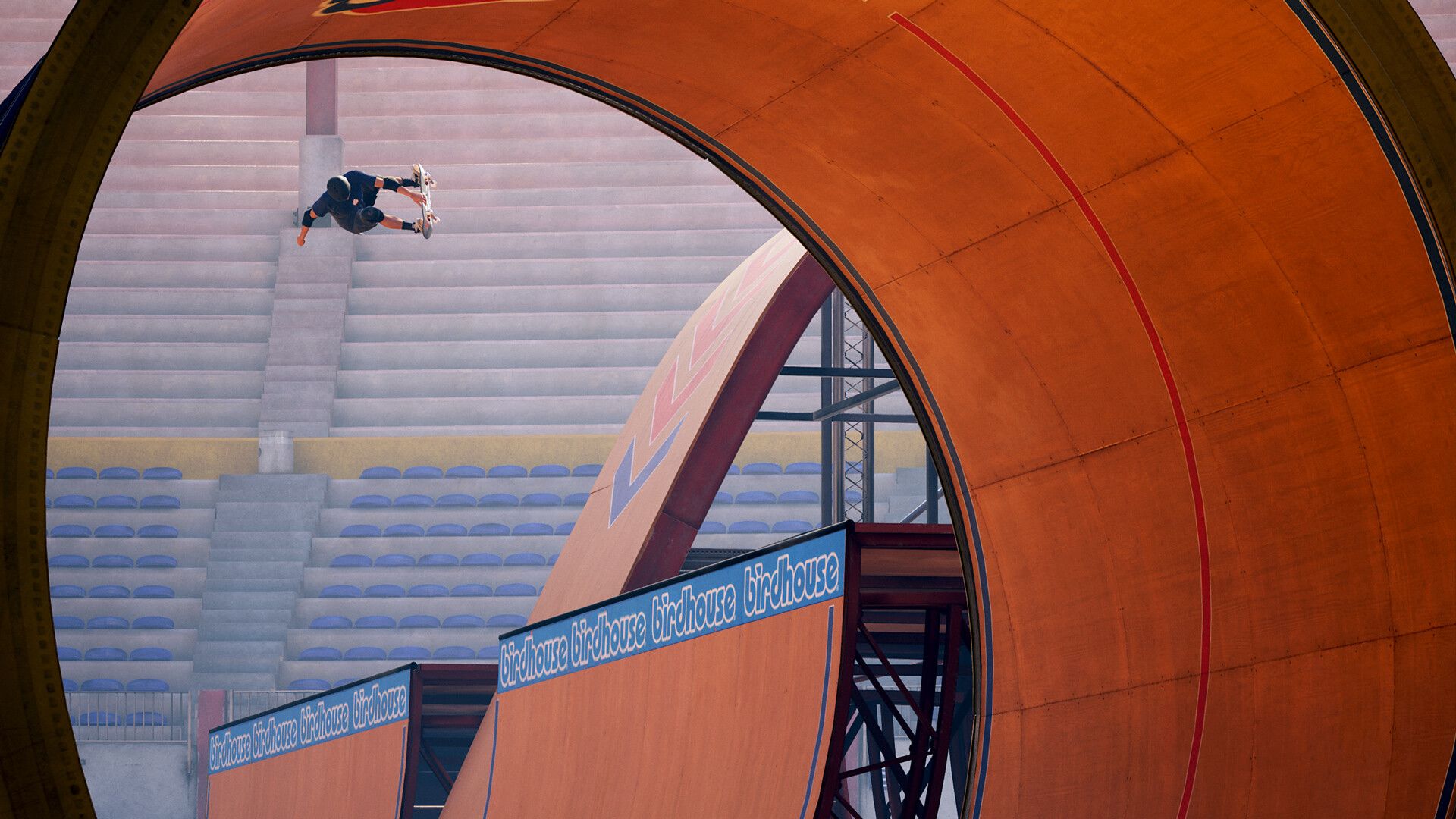 A skater launches above a large orange ramp inside an arena, showing the scale of the vert-skating spaces.