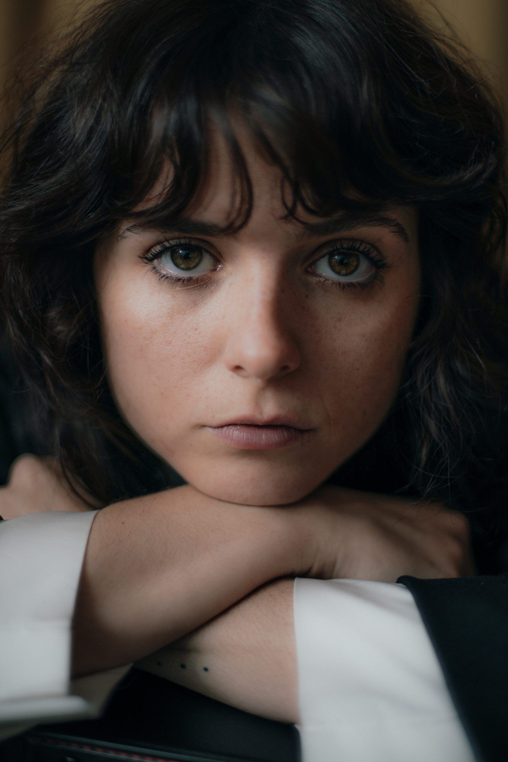 Gabrielle Creevy faces the camera in a close-up portrait against a dark background.