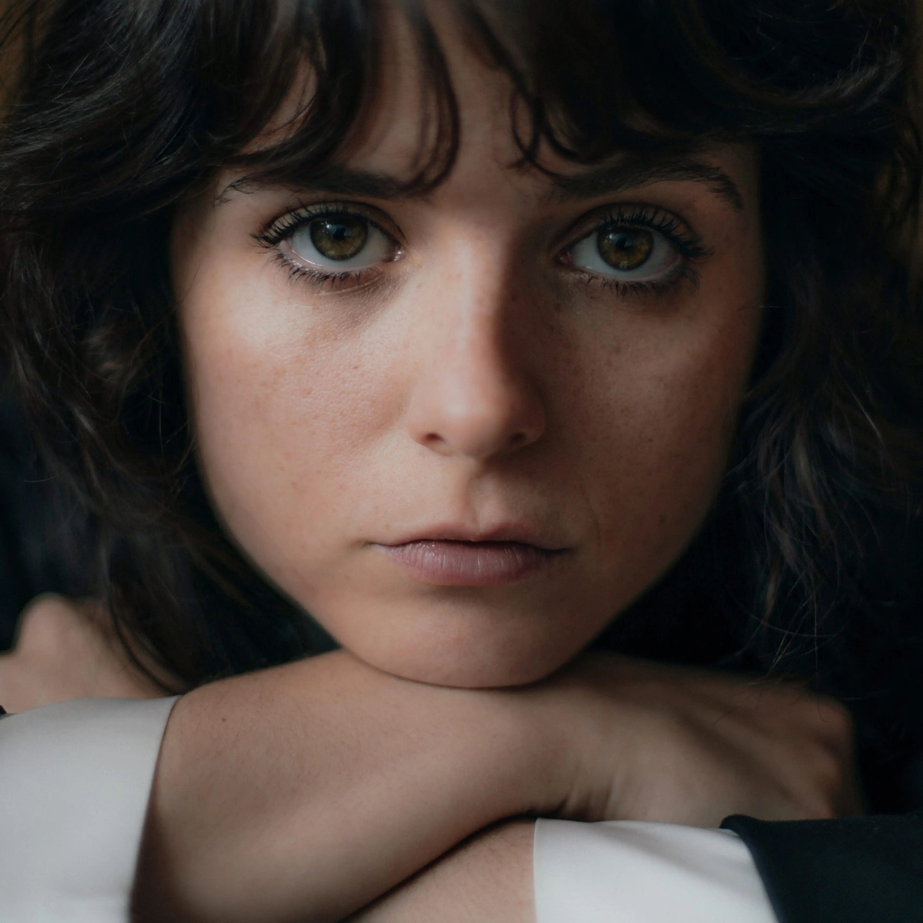 Gabrielle Creevy faces the camera in a close-up portrait against a dark background.