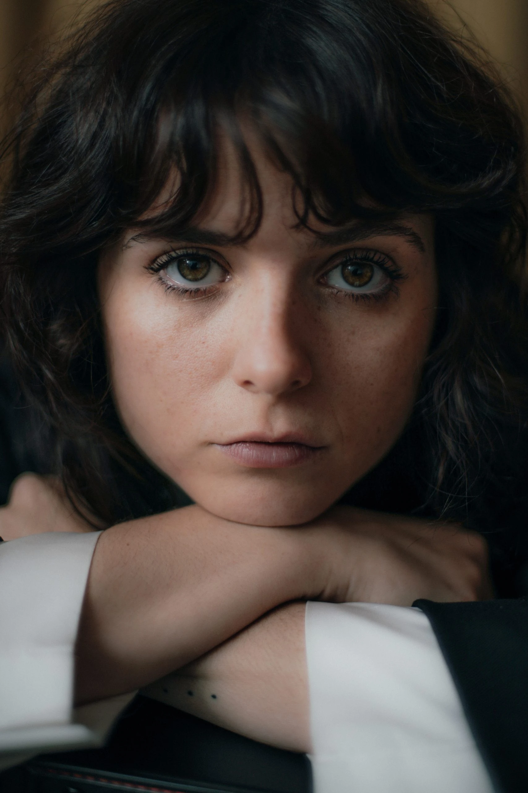 Gabrielle Creevy faces the camera in a close-up portrait against a dark background.
