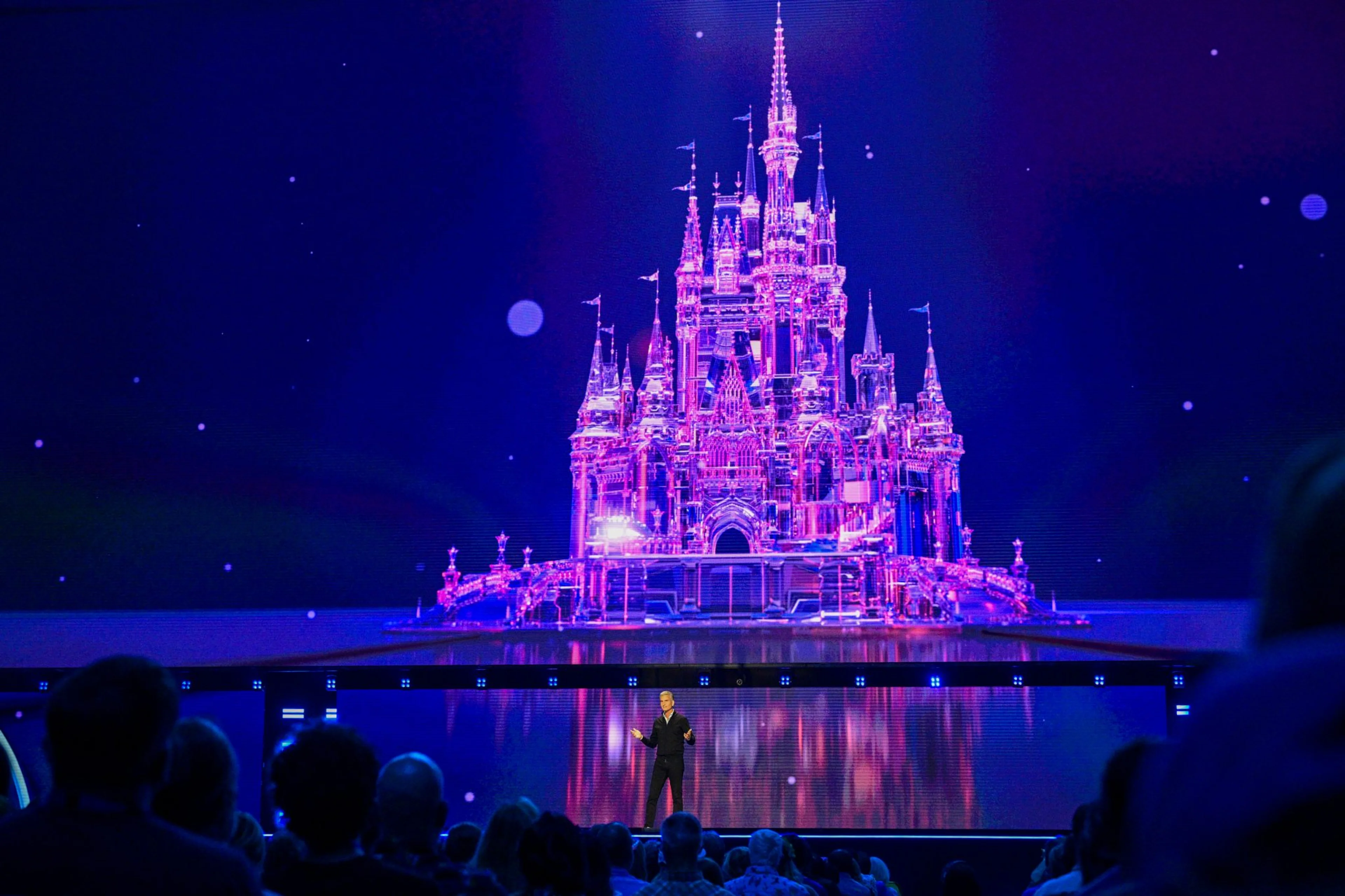 Disney chief executive Josh D’Amaro speaks onstage beneath a castle image at D23 2026.