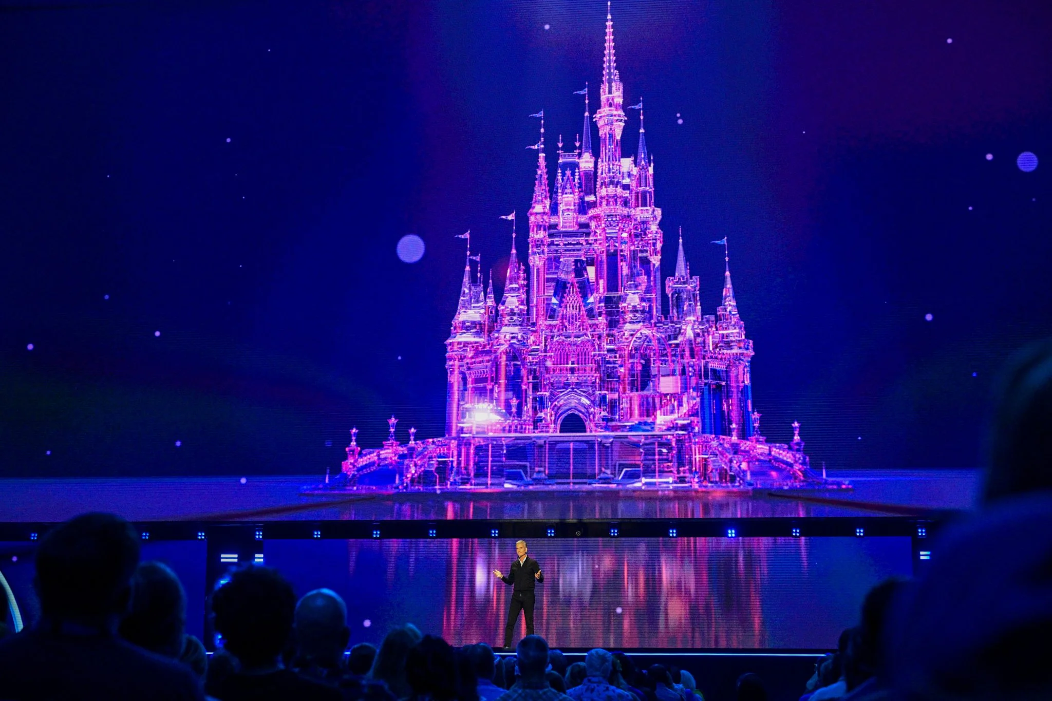 Disney chief executive Josh D’Amaro speaks onstage beneath a castle image at D23 2026.