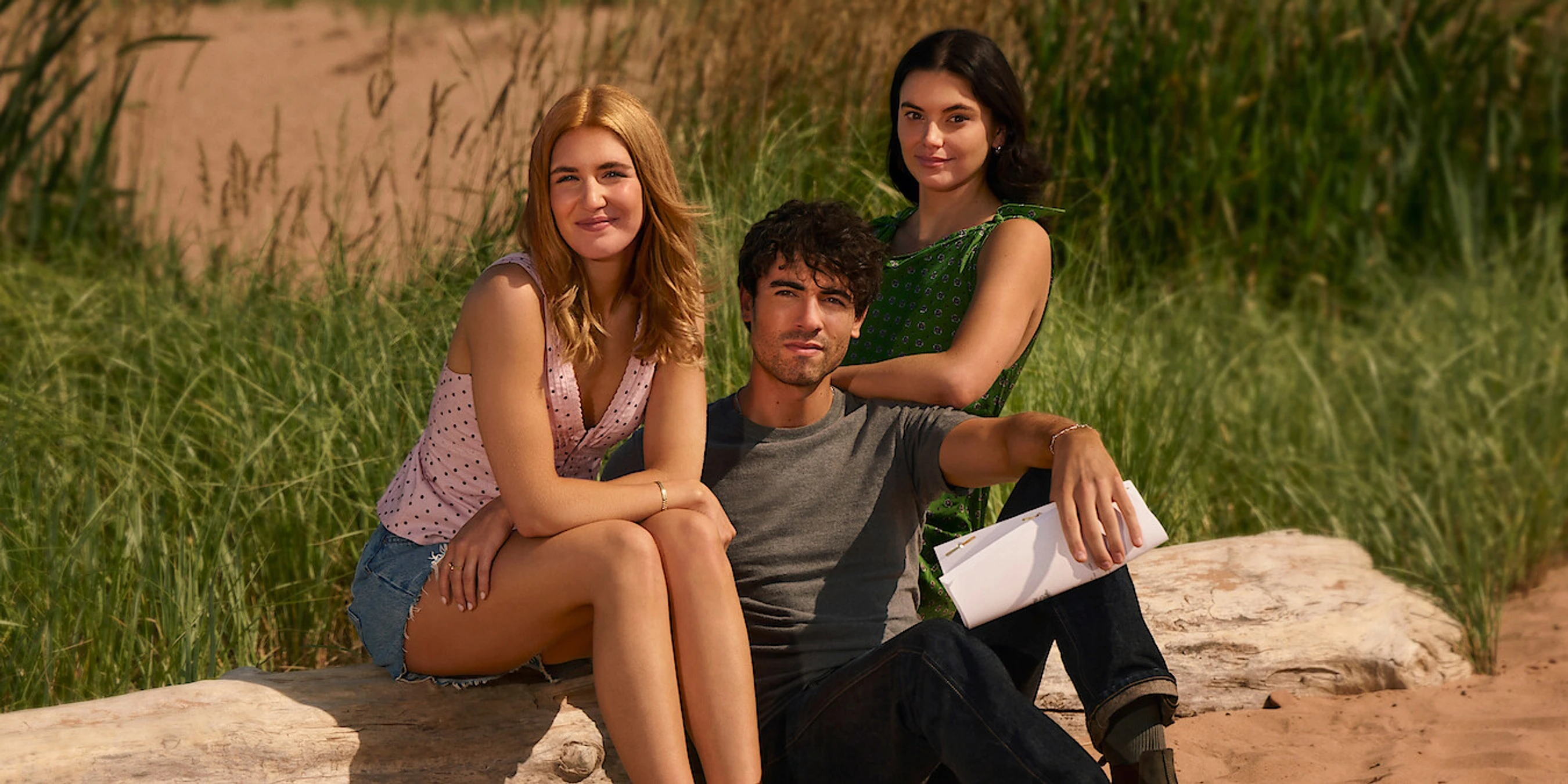 Sophie Nélisse, Roby Attal and Francesca Reale seated together on a beach for This Summer Will Be Different.