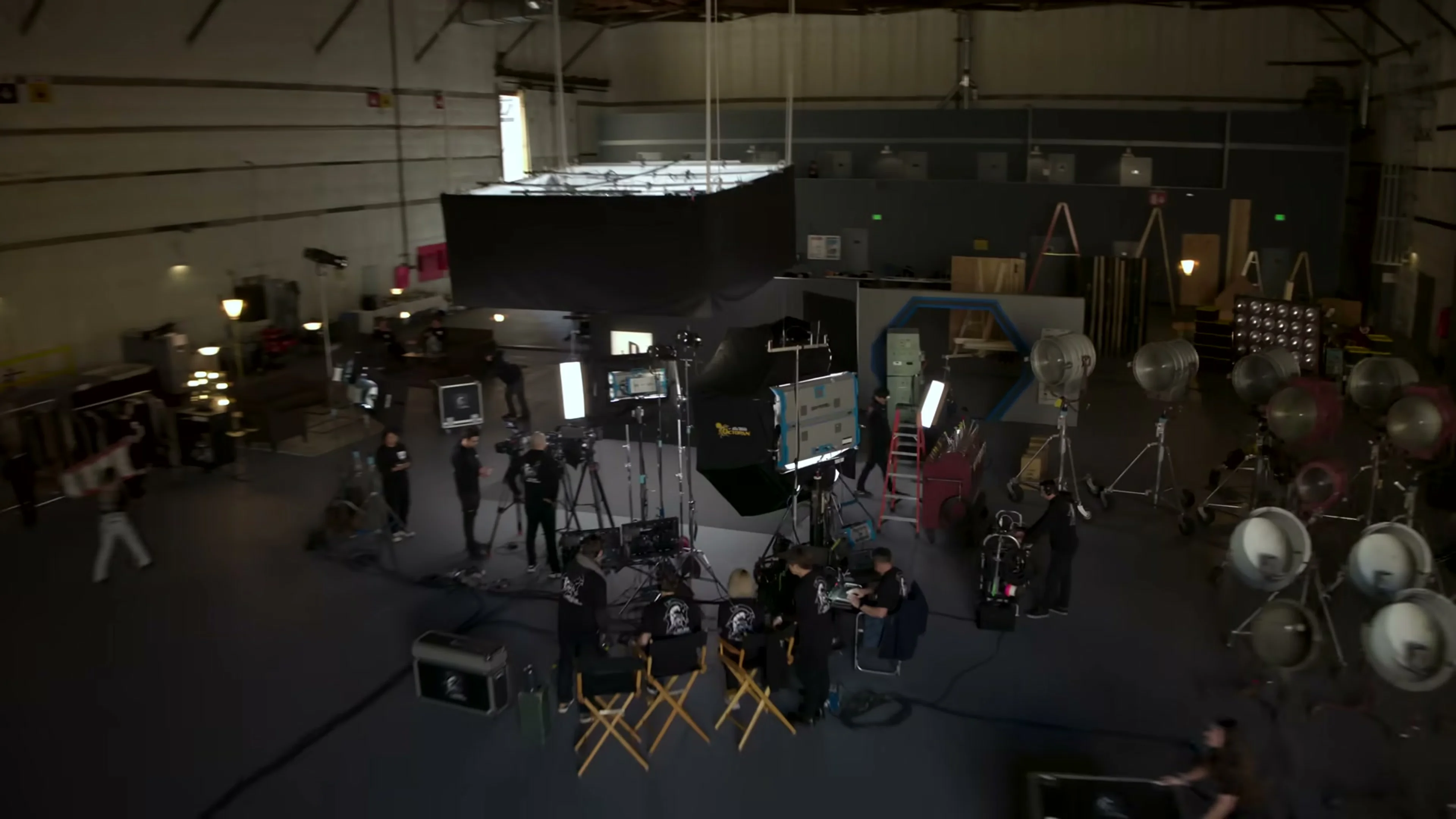 A film-production stage contains cameras, lights, monitors and crew equipment.
