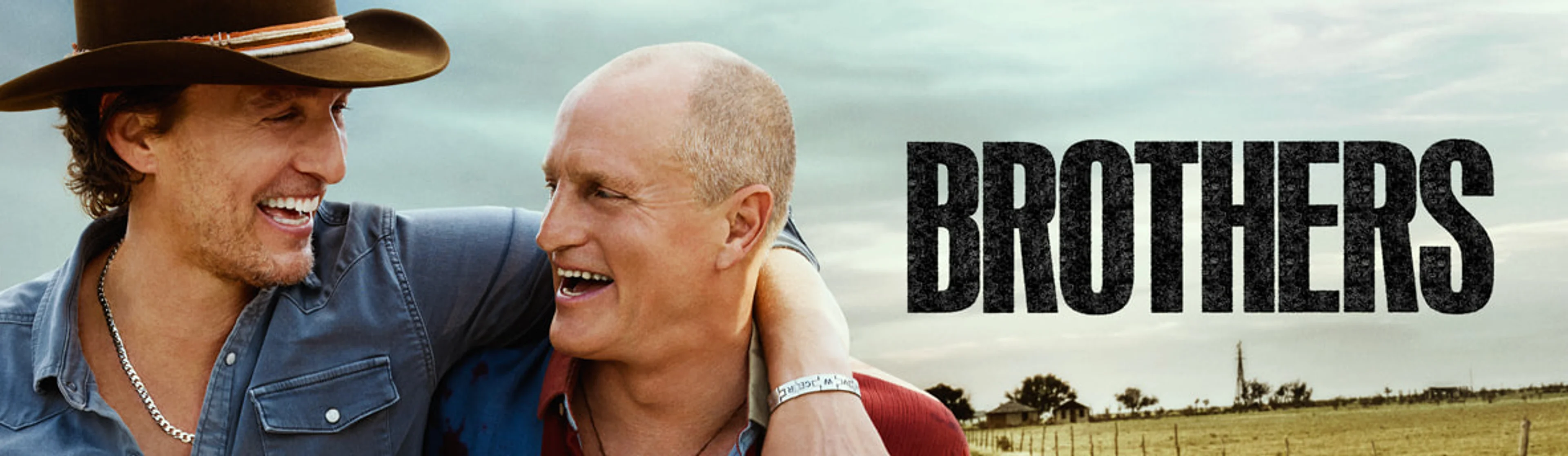 Matthew McConaughey and Woody Harrelson stand together in a sunlit field in official Brothers key art.