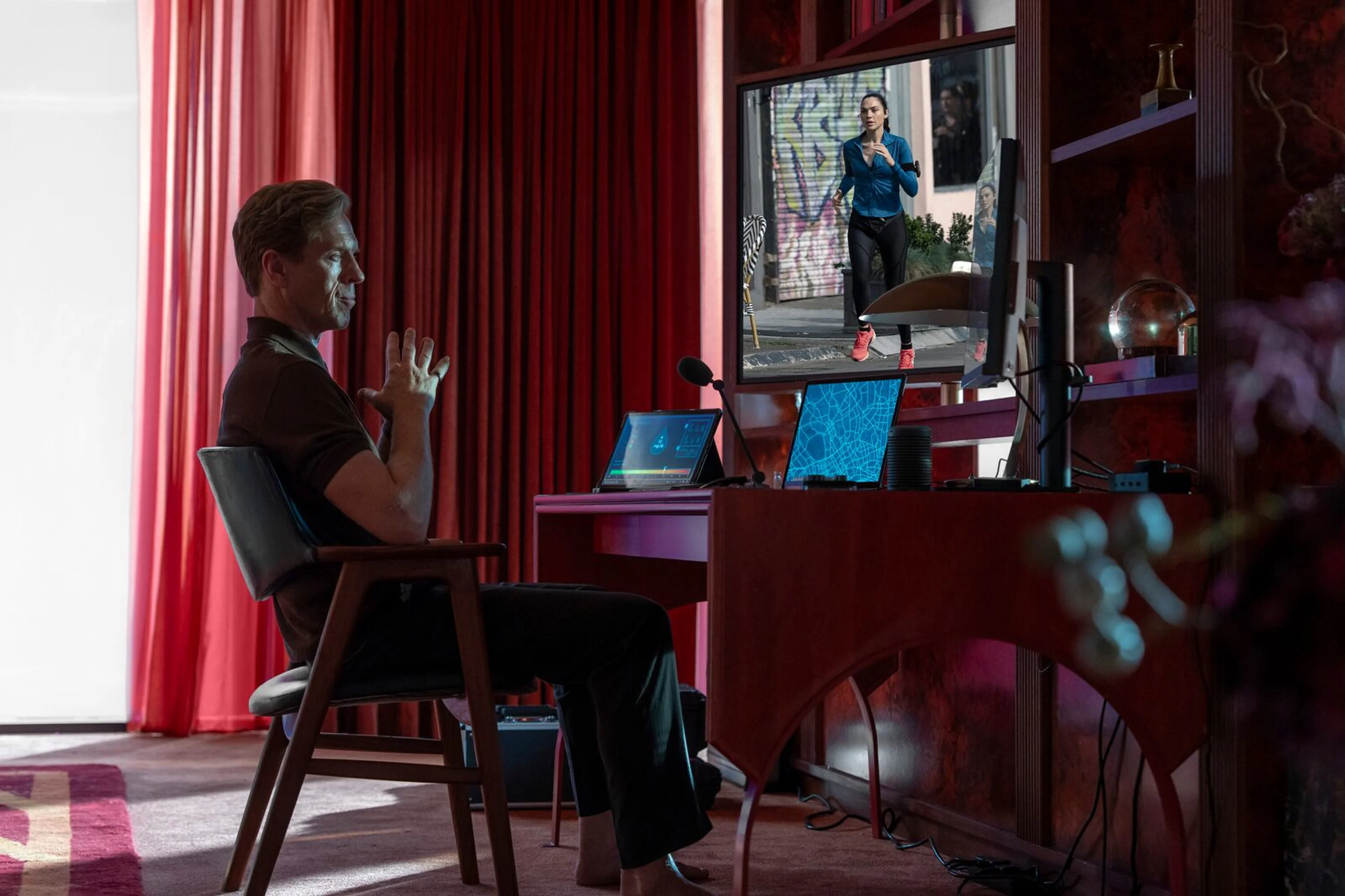 Damian Lewis as the Caller sits in front of several monitors in The Runner.