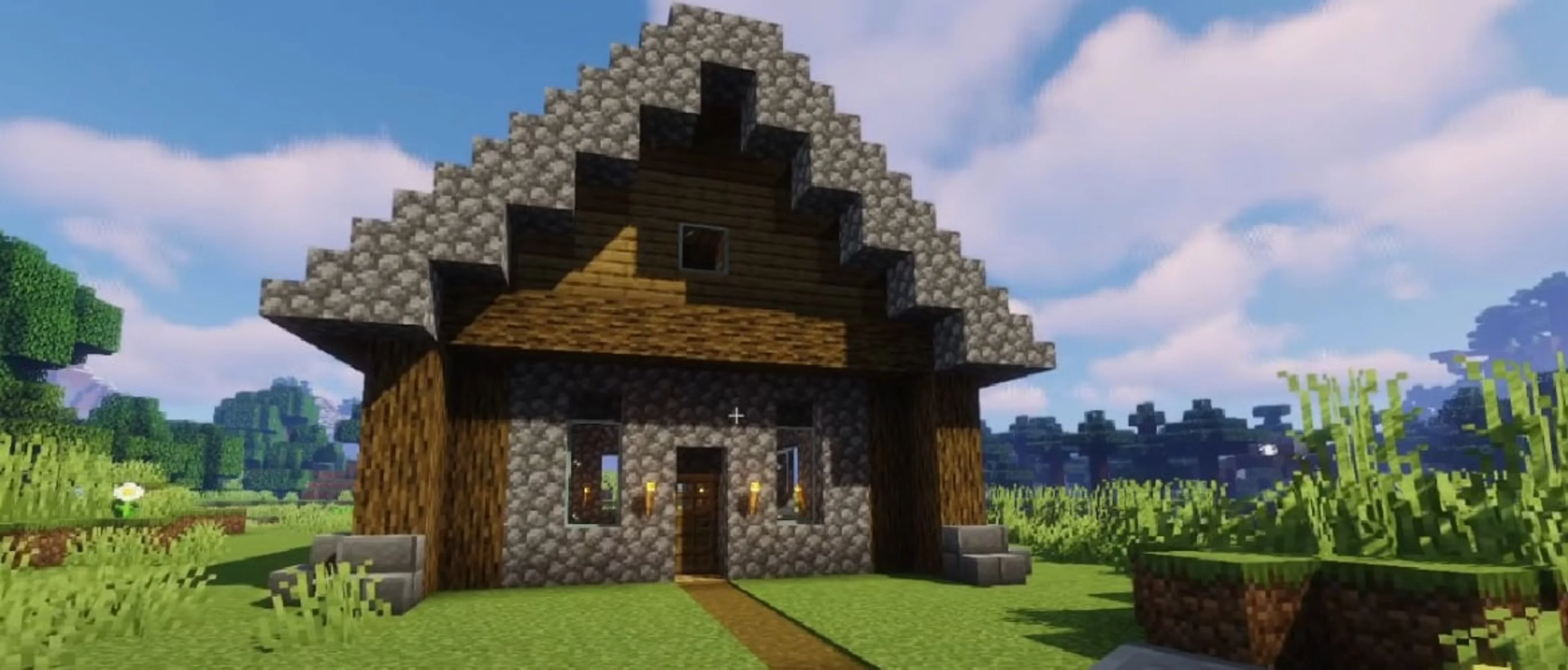 A small Minecraft house with a peaked roof, stone walls, logs, windows, and torches.