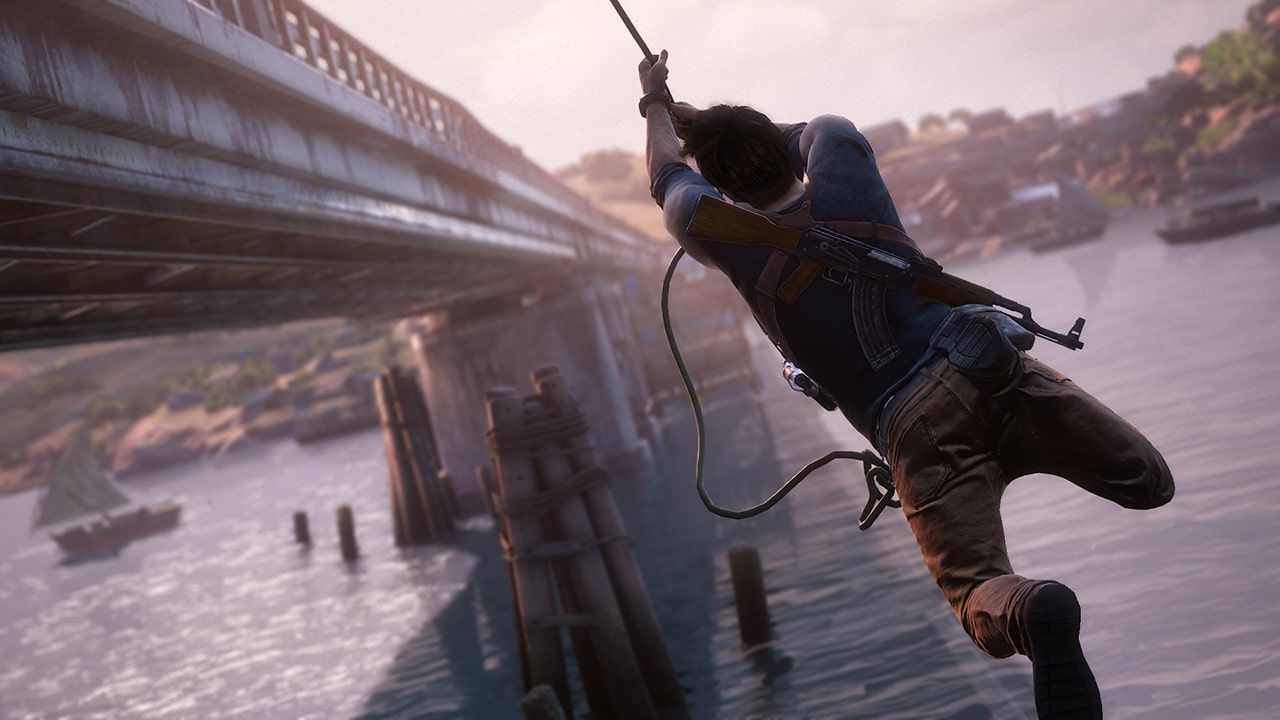 Nathan holding a rope above water beside a building and boats.