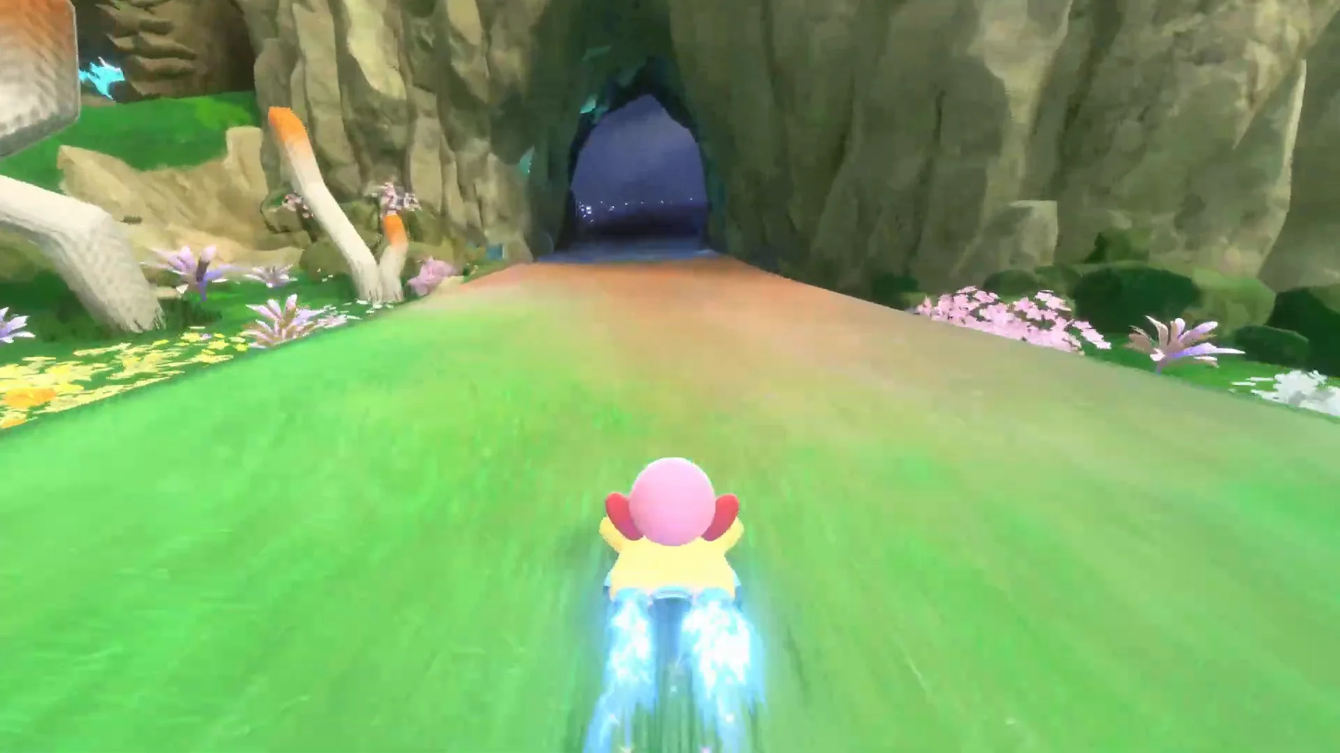 Official Nintendo UK Kirby Air Riders gameplay frame with bright blue boost jets behind Kirby’s Warp Star on the straight after a corner.