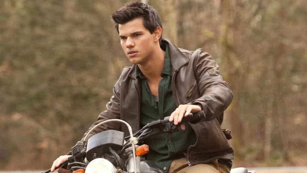 Jacob Black sits on a motorcycle in a Twilight film scene.