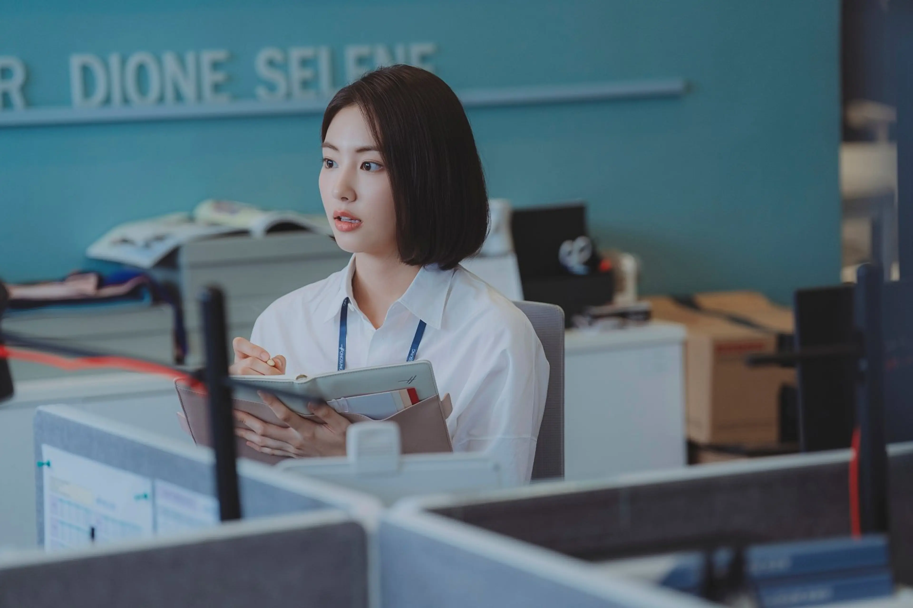 Lee Ji-hye holds her notebook at her desk.