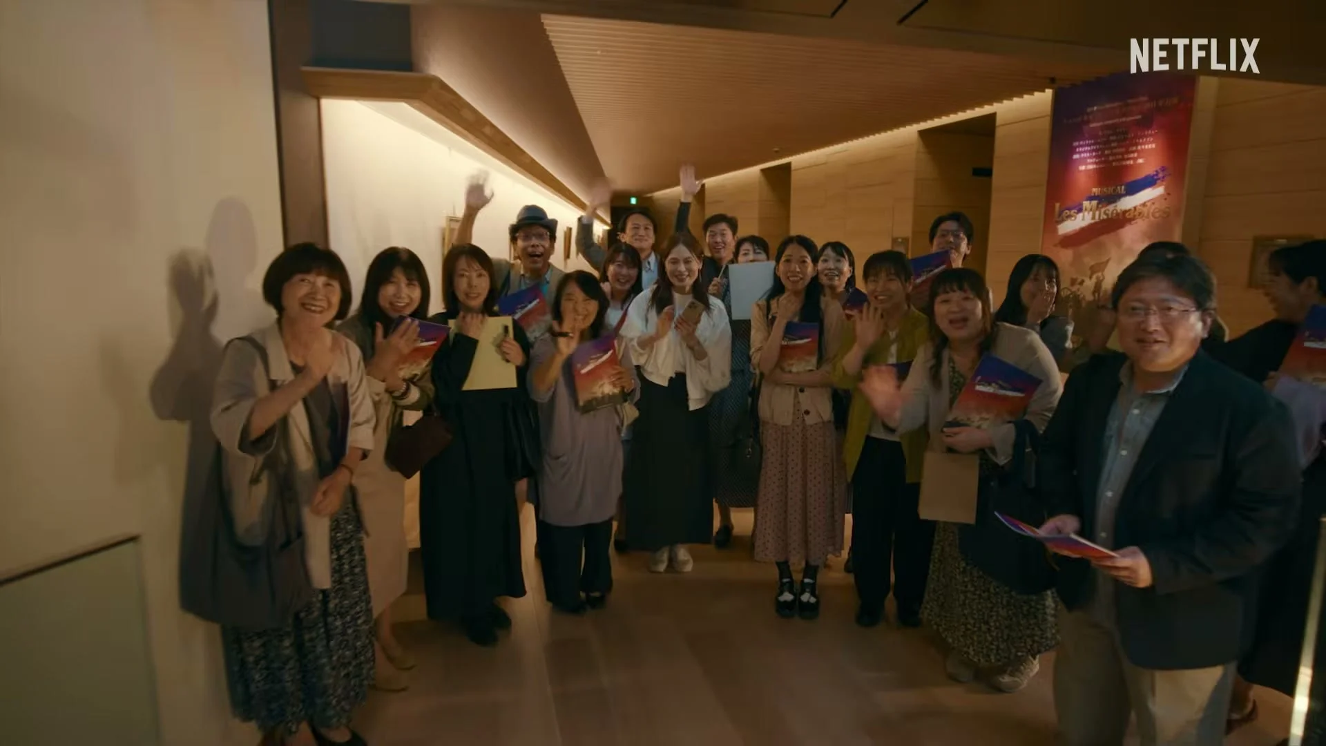 A large group of actors gathers inside a film production office.