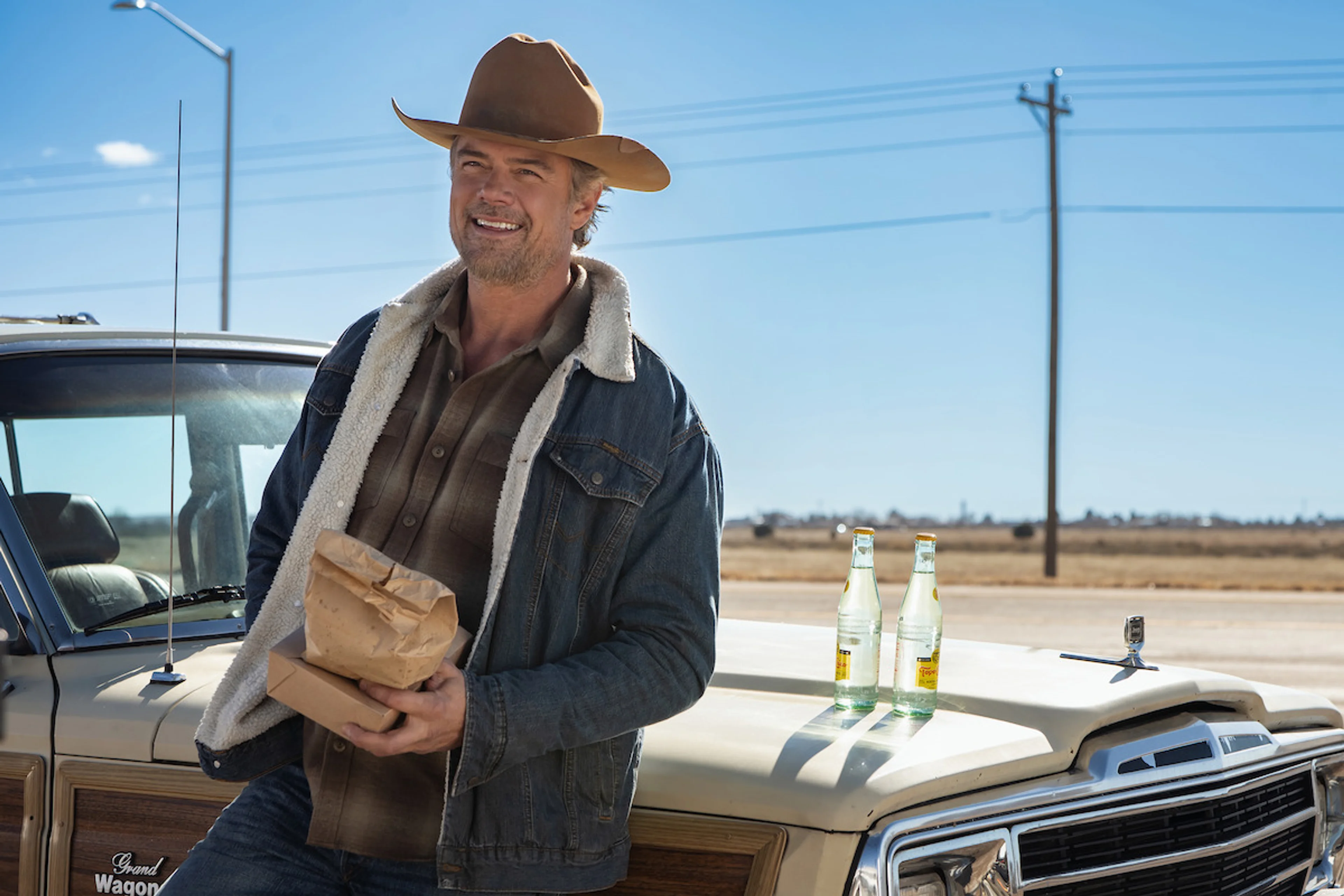 Josh Duhamel as Staten Kirkland stands beside a vintage Jeep in Ransom Canyon Season 2.