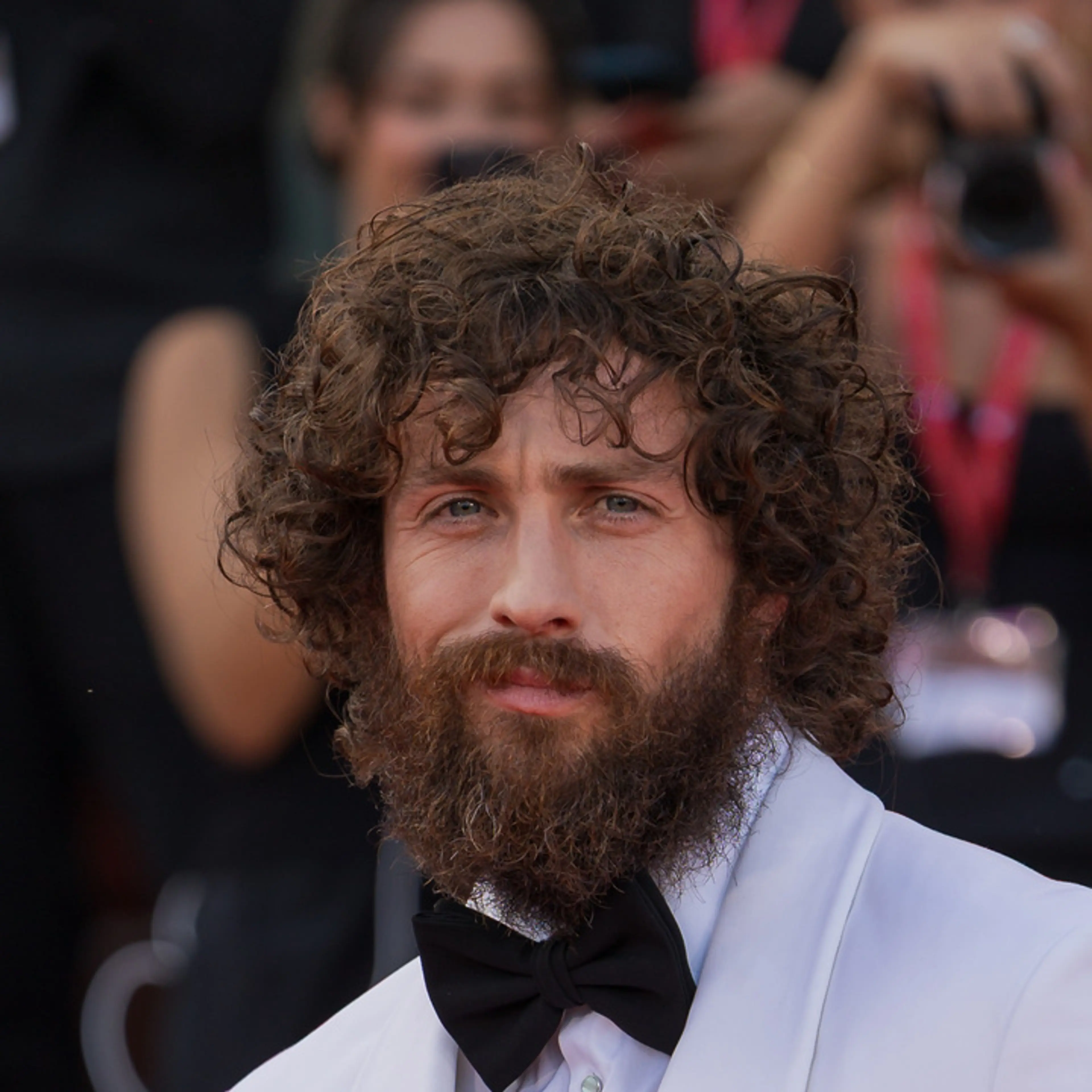 Close-up of Aaron Taylor-Johnson in a pale suit at the Venice Film Festival.