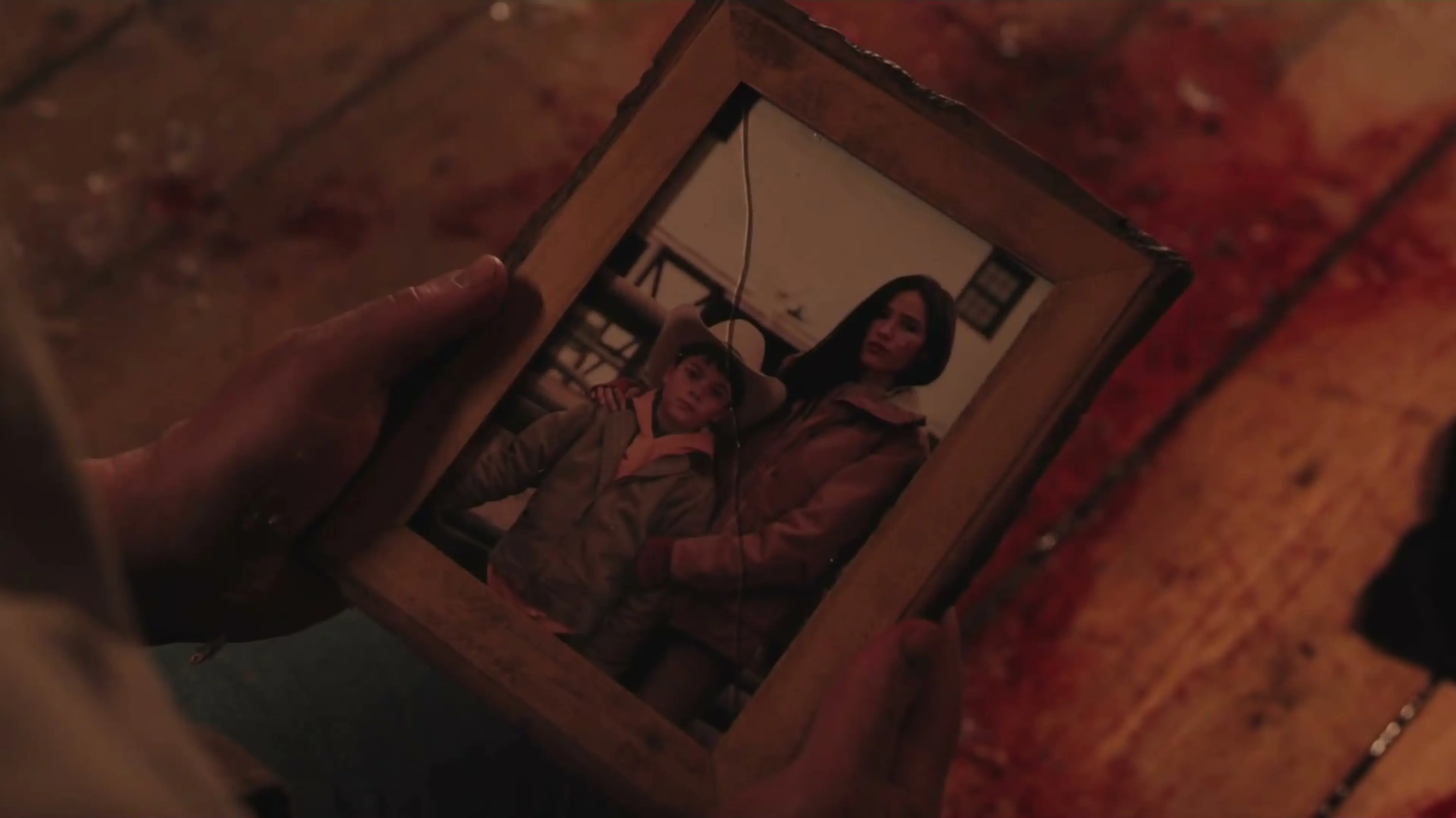 A hand holds an old family photograph in Marshals Season 2.