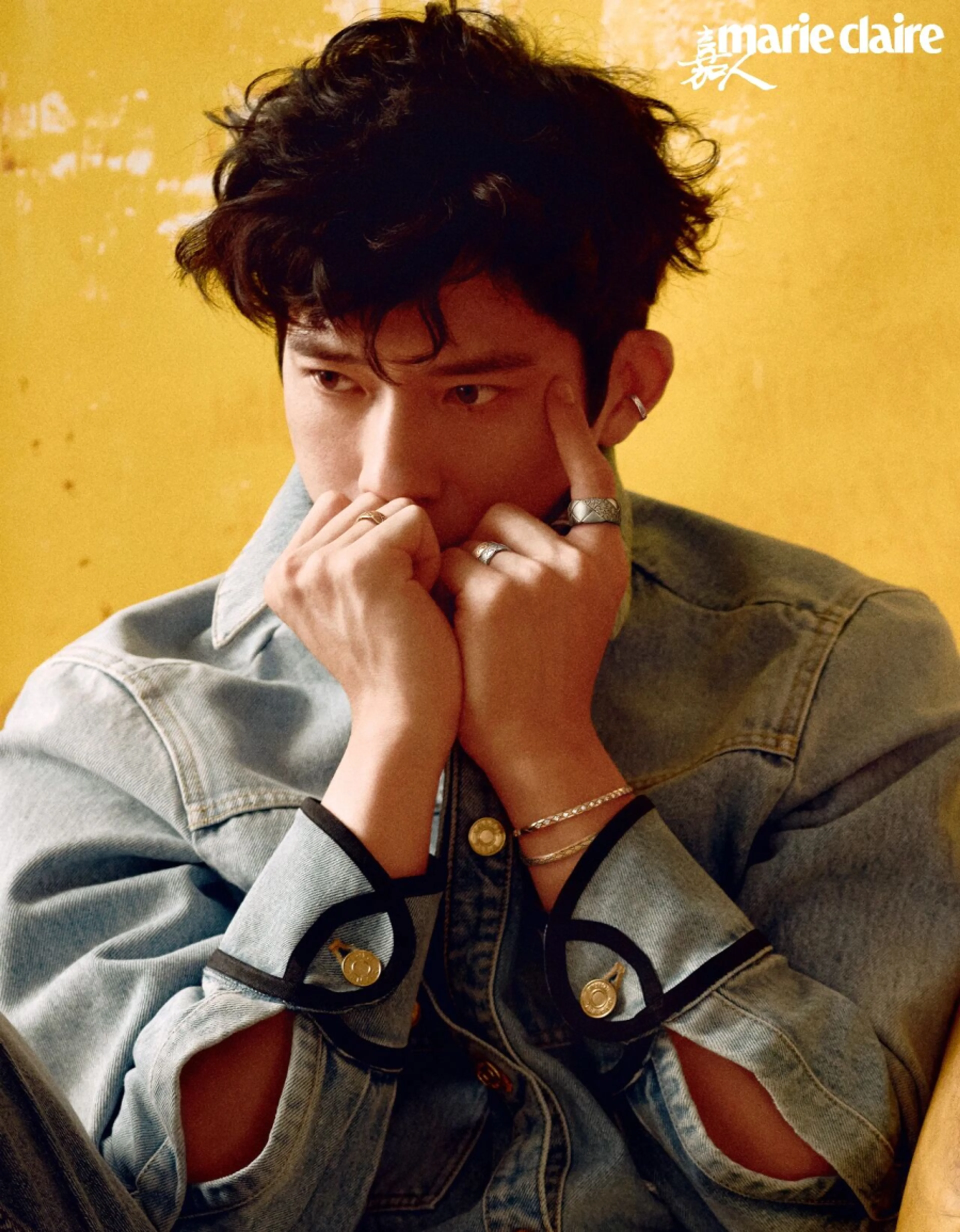 Jing Boran in a denim jacket against a yellow backdrop for Marie Claire China.