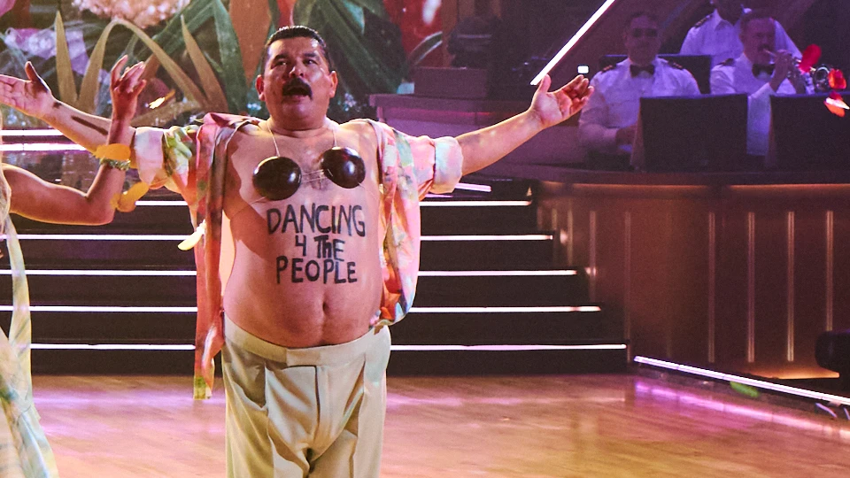 Guillermo Rodriguez opens his floral shirt to show Dancing With the People as confetti falls.