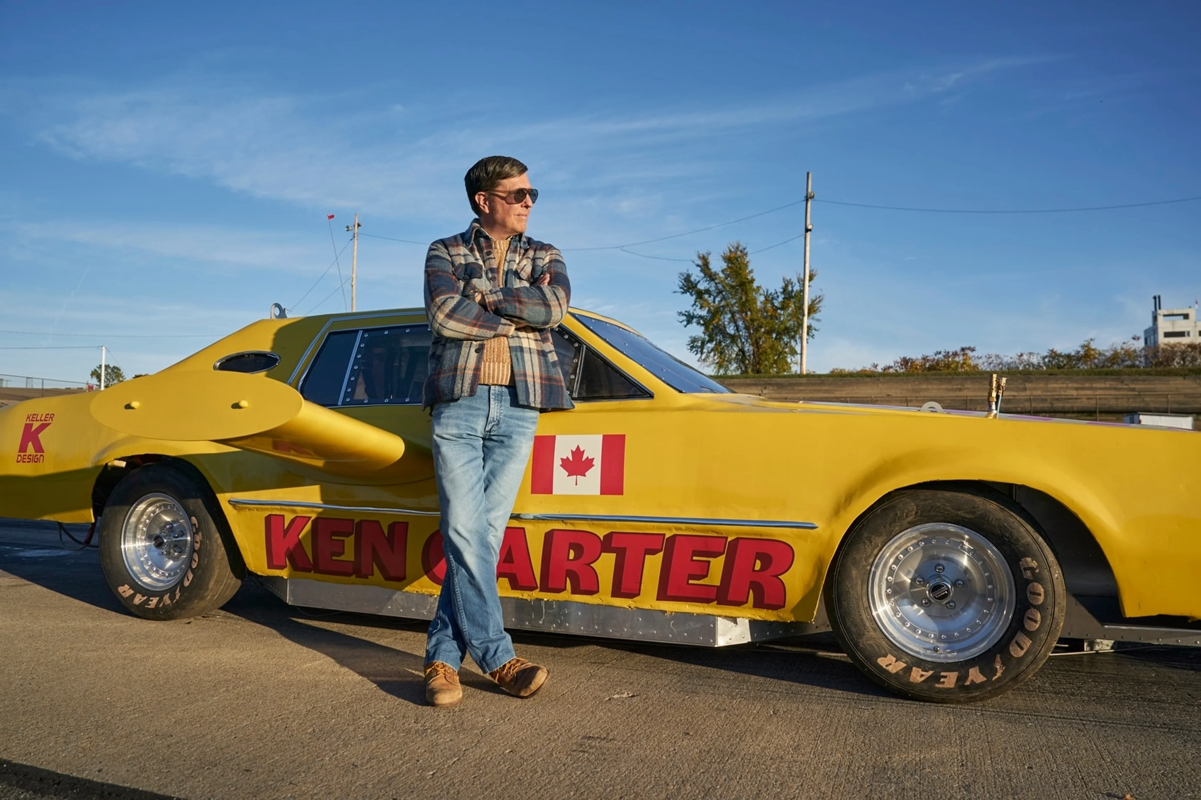 Ken Carter stands beside the yellow car bearing his name.