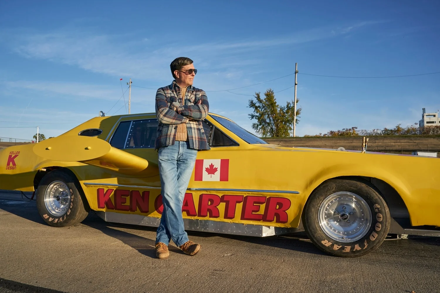 Ken Carter stands beside the yellow car bearing his name.