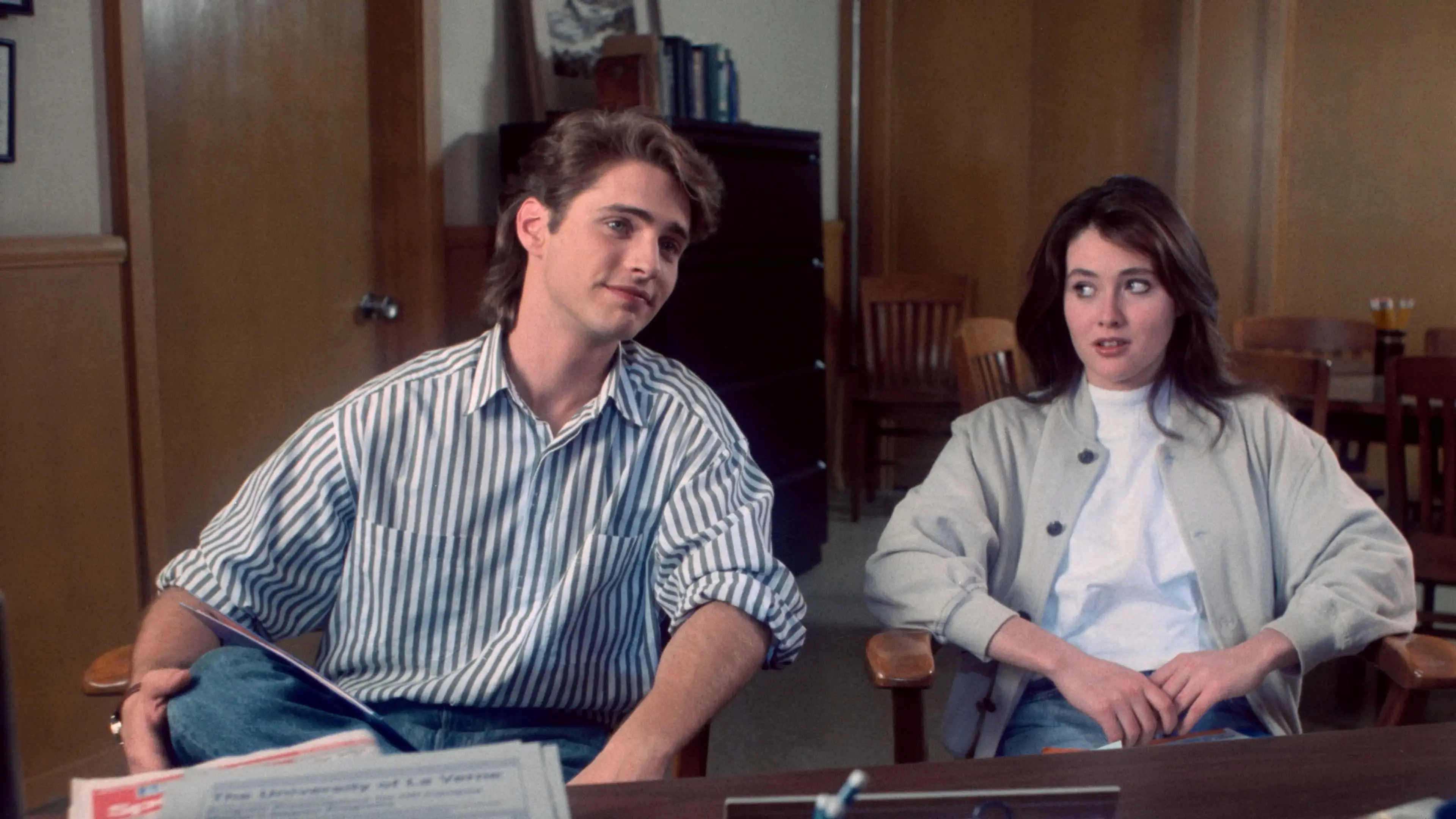 Jason Priestley and Shannen Doherty sit beside each other as Brandon and Brenda Walsh in Beverly Hills, 90210.