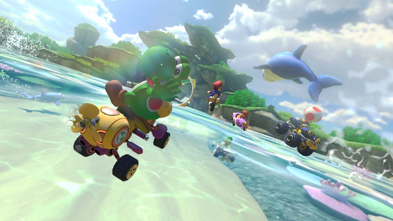 Racers drive a tilted seaside course with a dolphin in the background.