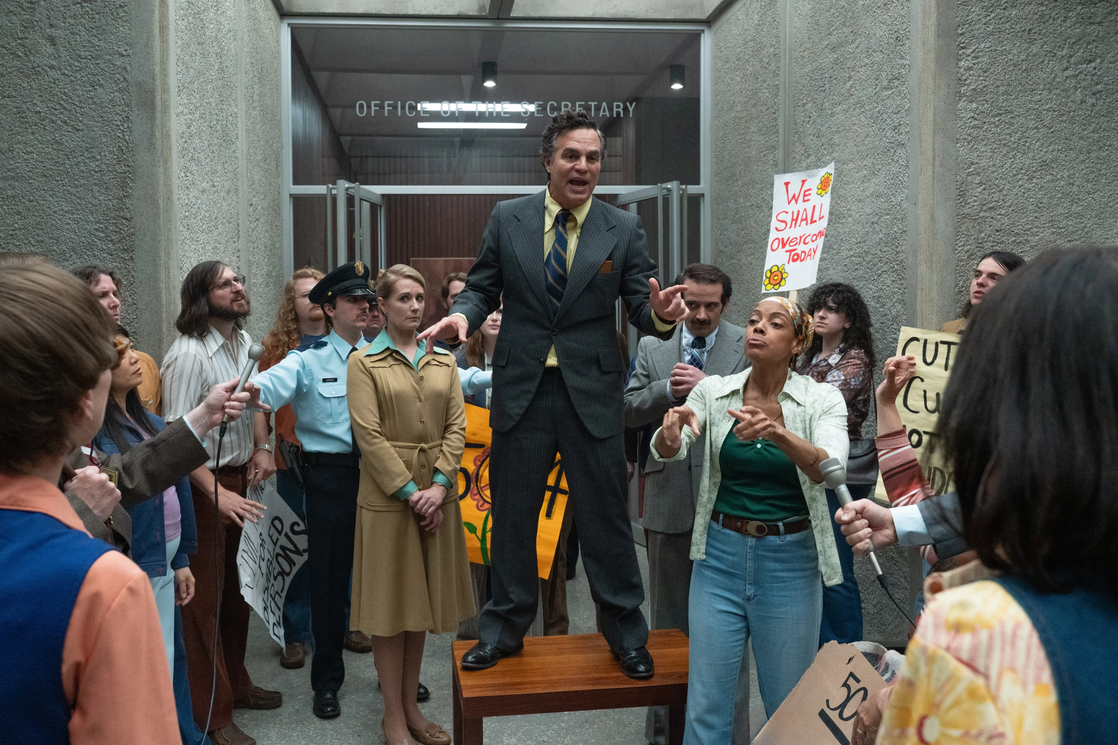 Mark Ruffalo as Joseph Califano stands before disability-rights protesters outside a federal office in Being Heumann.