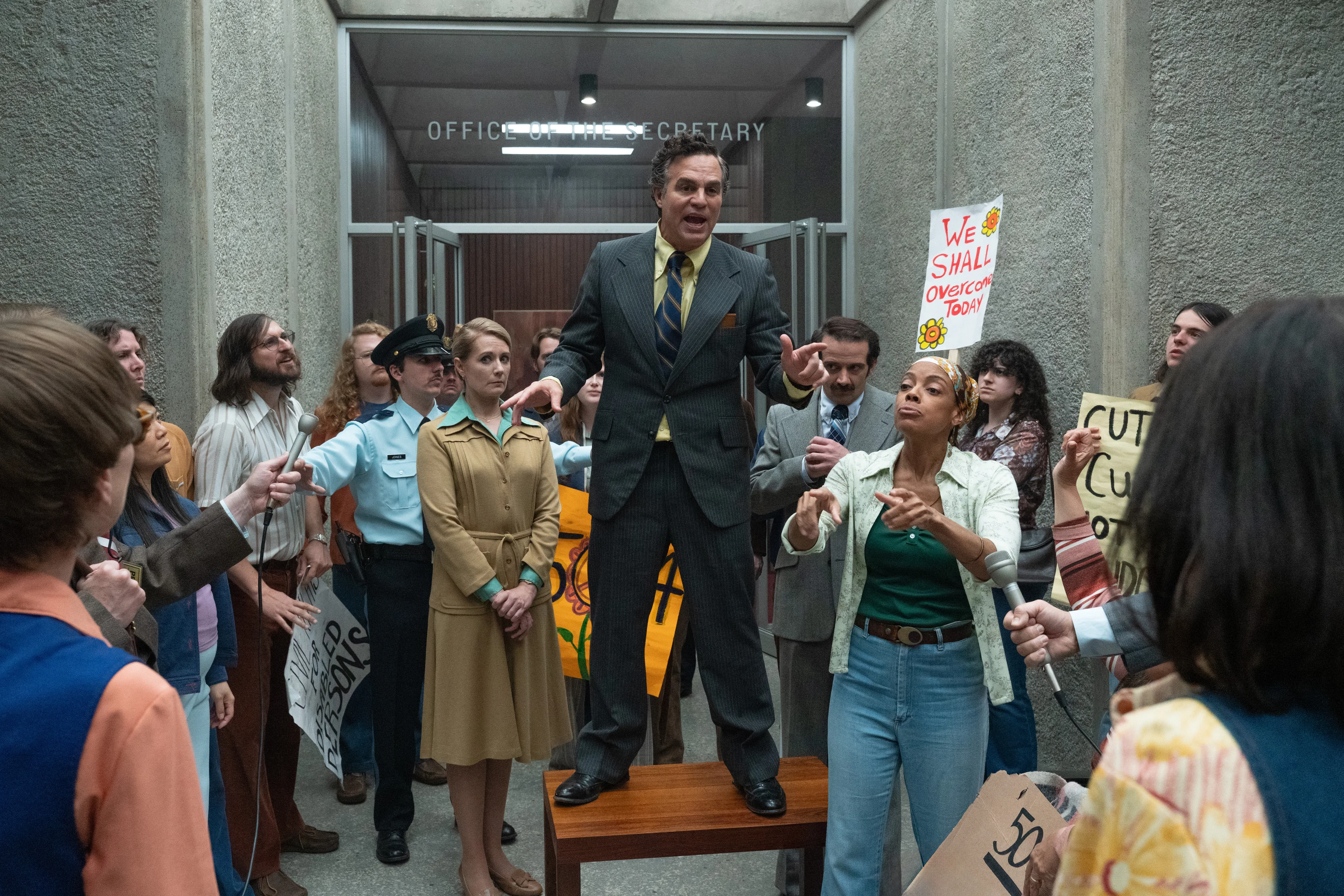 Mark Ruffalo as Joseph Califano stands before disability-rights protesters outside a federal office in Being Heumann.