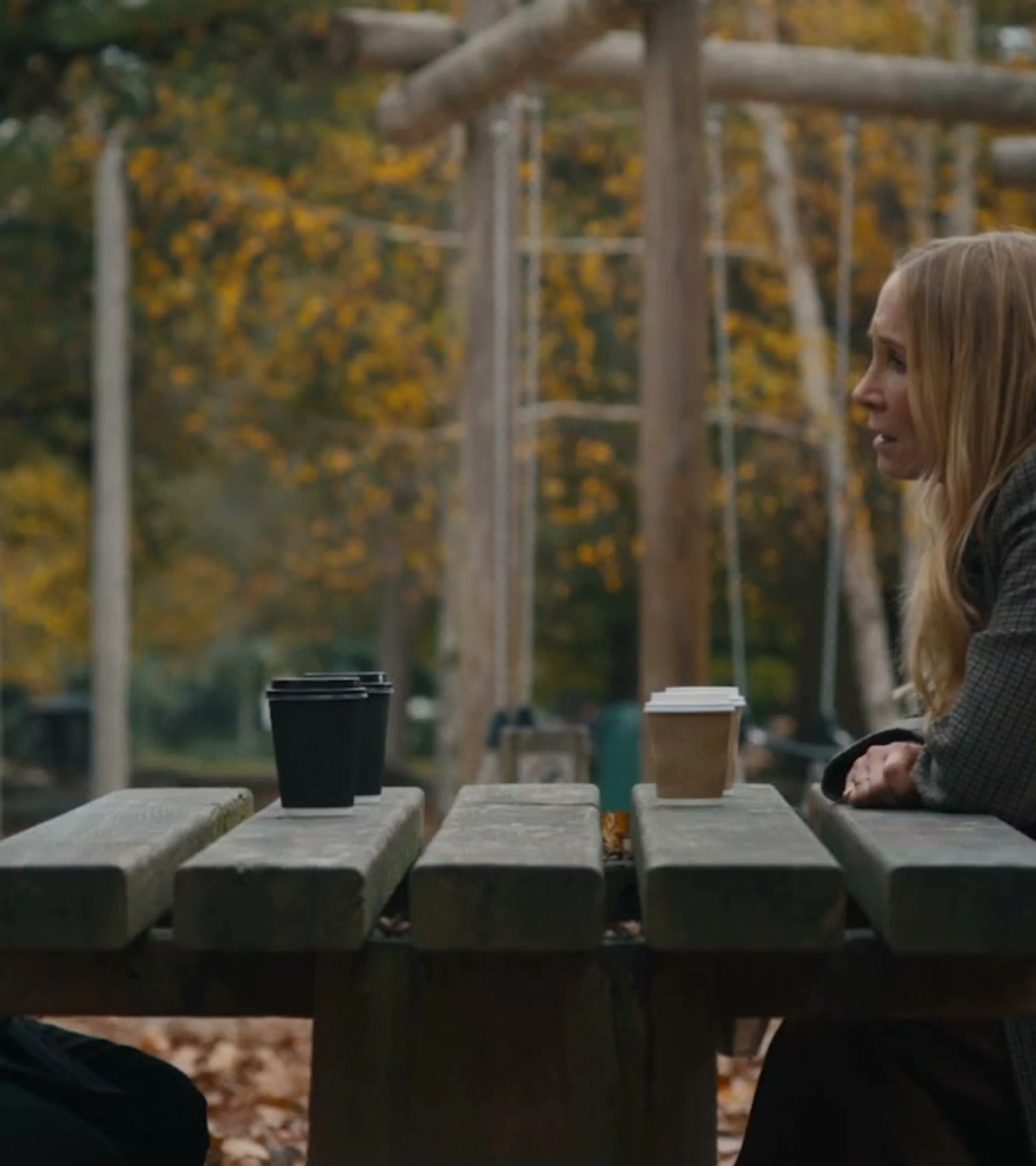 Harry da Souza and a woman speak across a picnic table in MobLand season two.