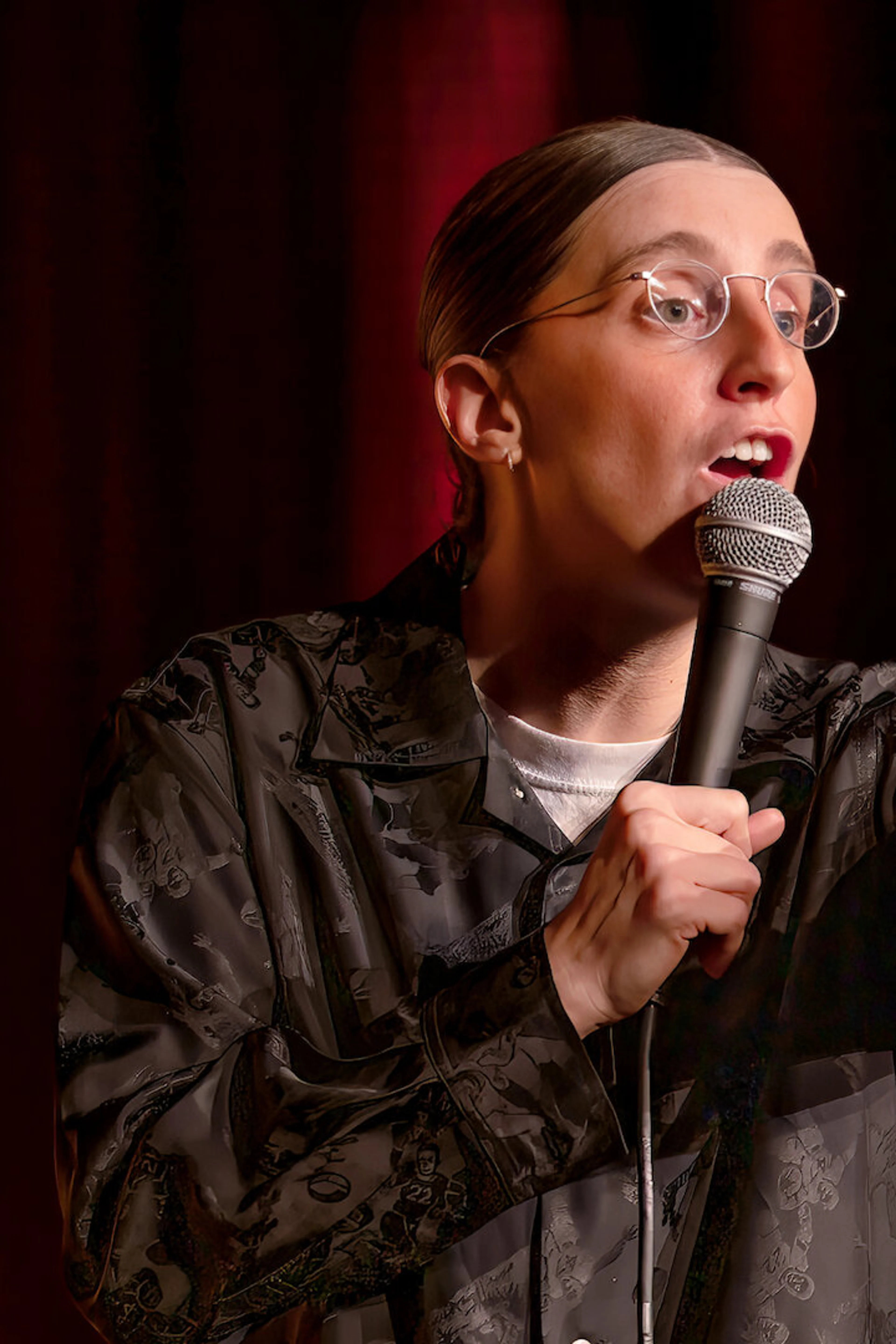 Robby Hoffman points into the audience while holding a microphone in her Netflix special Wake Up.