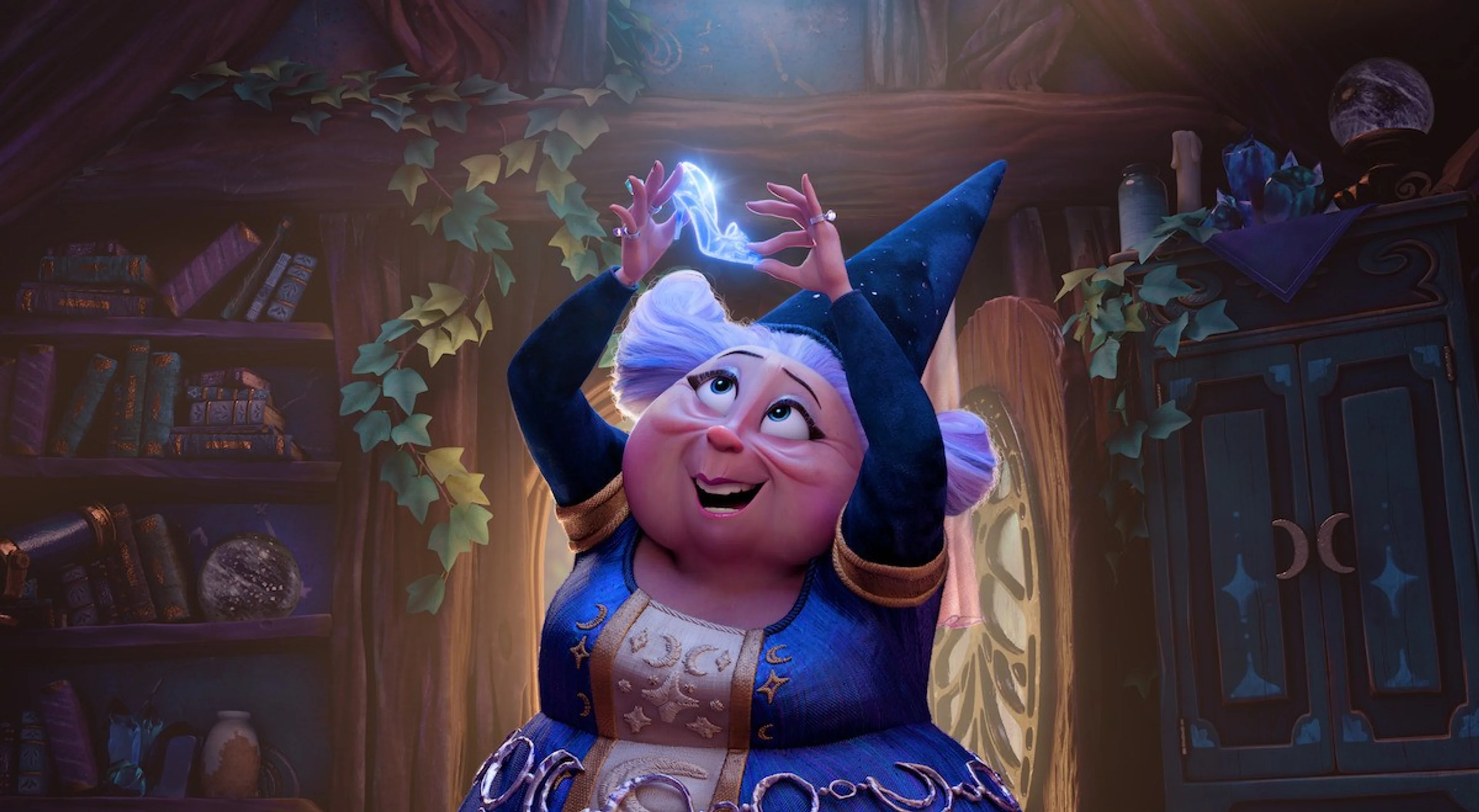 The Fairy Godmother holds glowing magic in a room full of books.