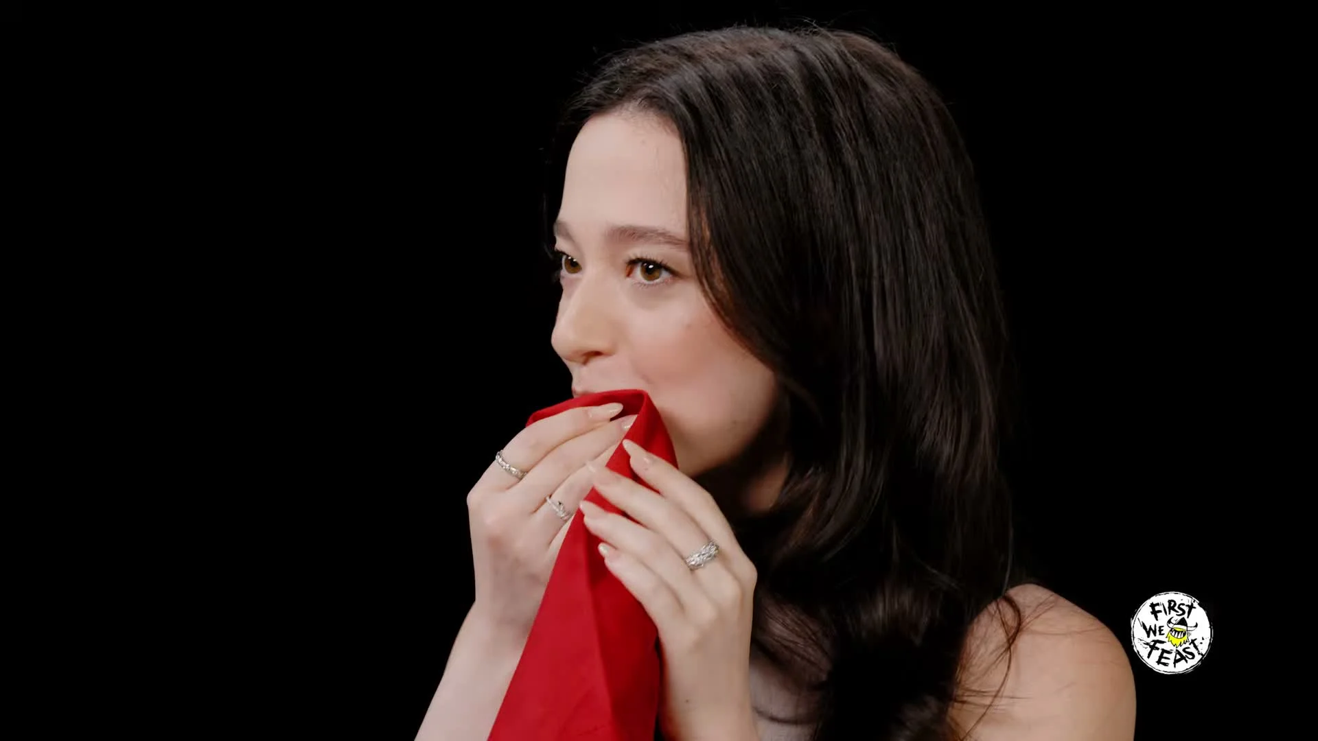 Mikey Madison presses a red napkin to her mouth during Hot Ones.